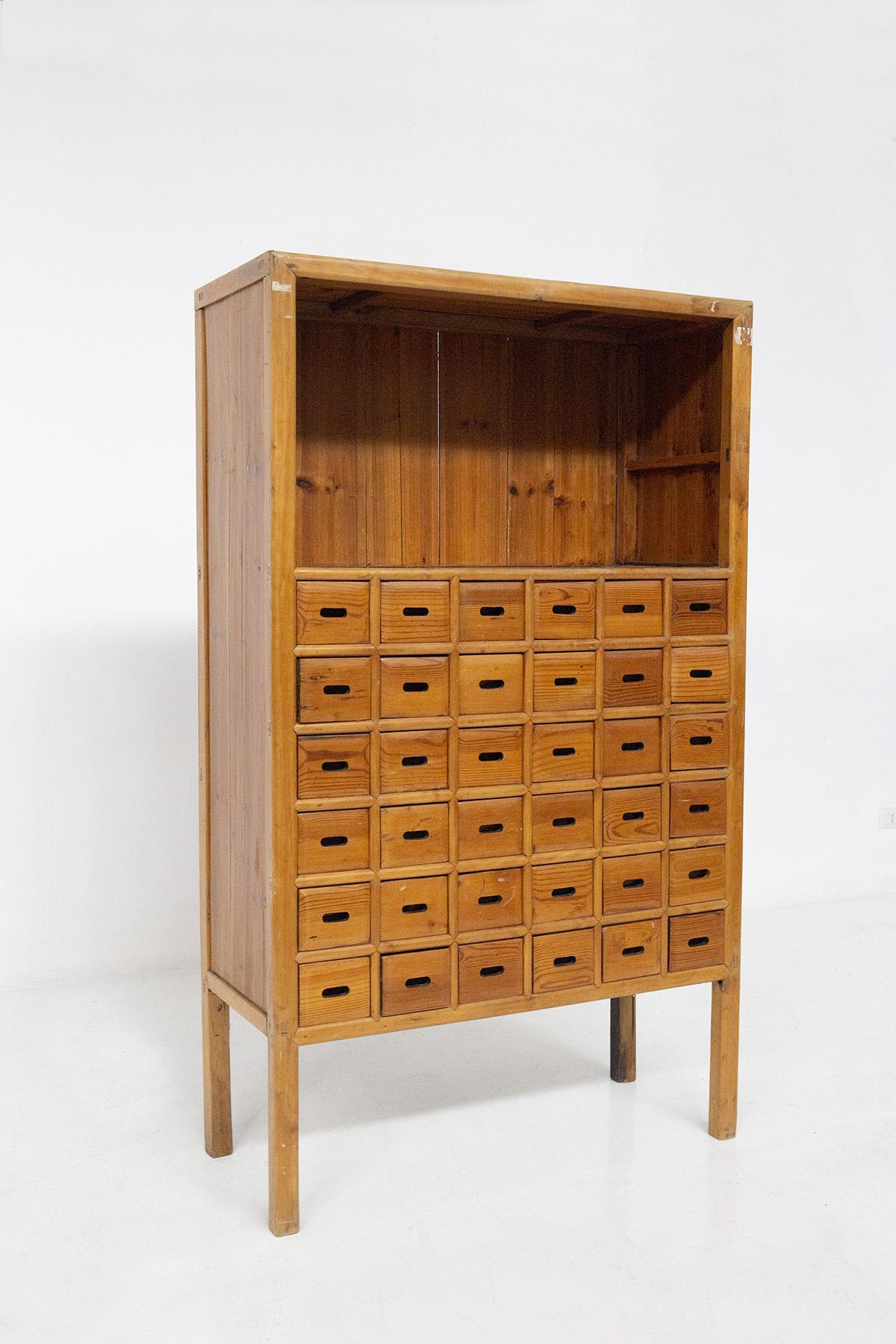 Italian storage cabinet from the early 1900s. The cabinet is made of larch wood, excellent workmanship and processing and technique of wood. The cabinet features a series of many industrial-style drawers where various objects can be stored. Each