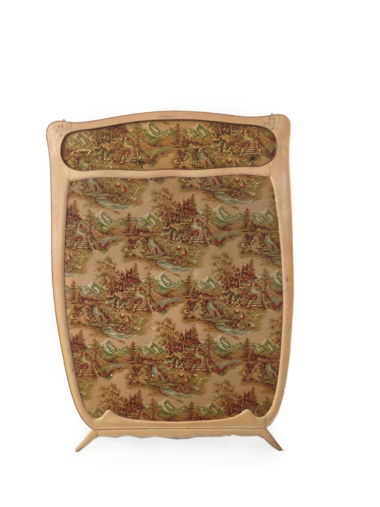 Italian wall-mounted coat rack, manufactured in the 1950s. It is made of a wooden frame and a back surface of textile filled with cotton wool with a washable cover with mountain landscape and forest motive with workers and enriched with beautiful