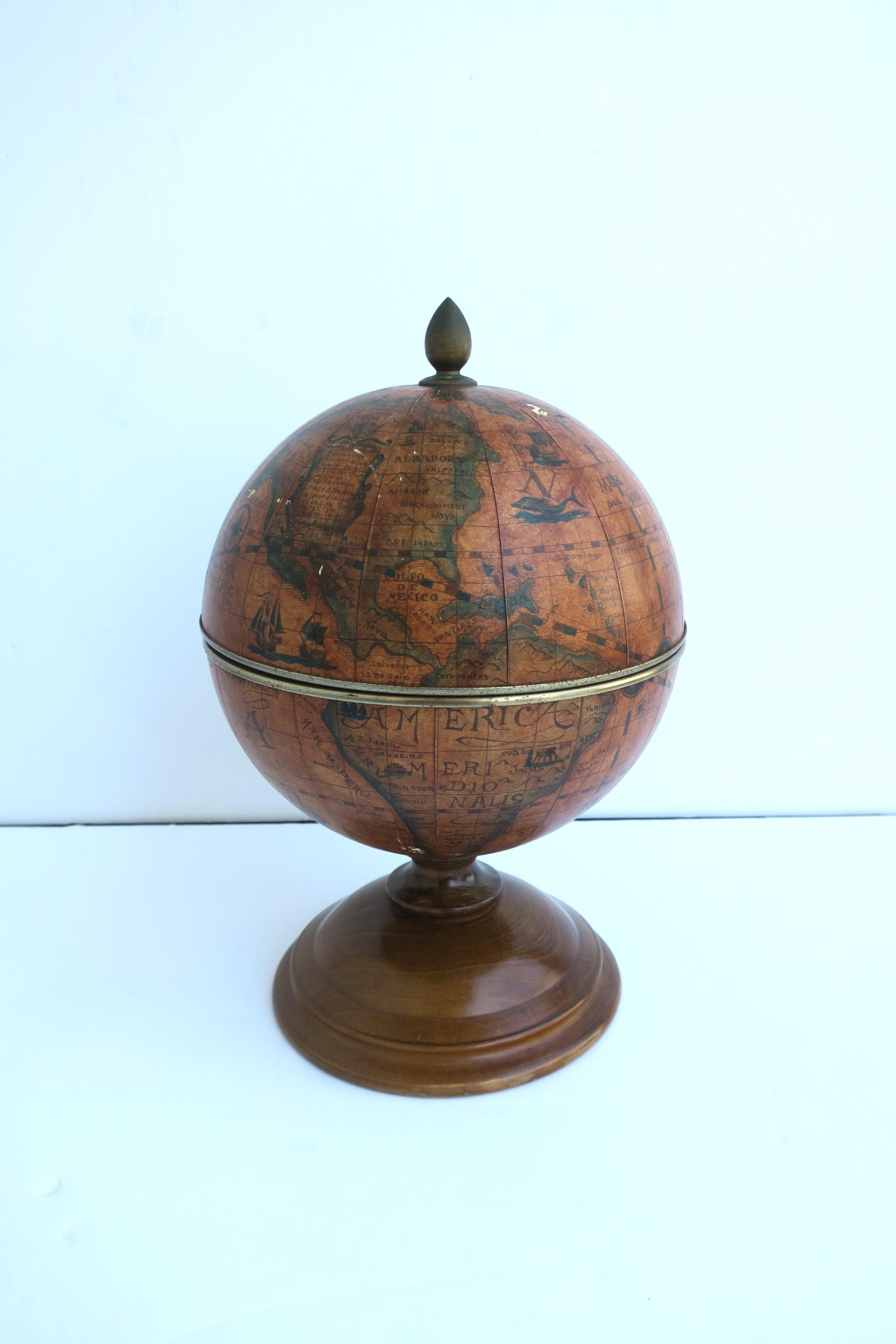 An Italian world globe ice bucket, Midcentury Modern design period, circa mid-20th century, Italy. Ice bucket has a brass finial top and a turned wood base. A great piece for entertaining, on a bar, bar cart, etc. 


