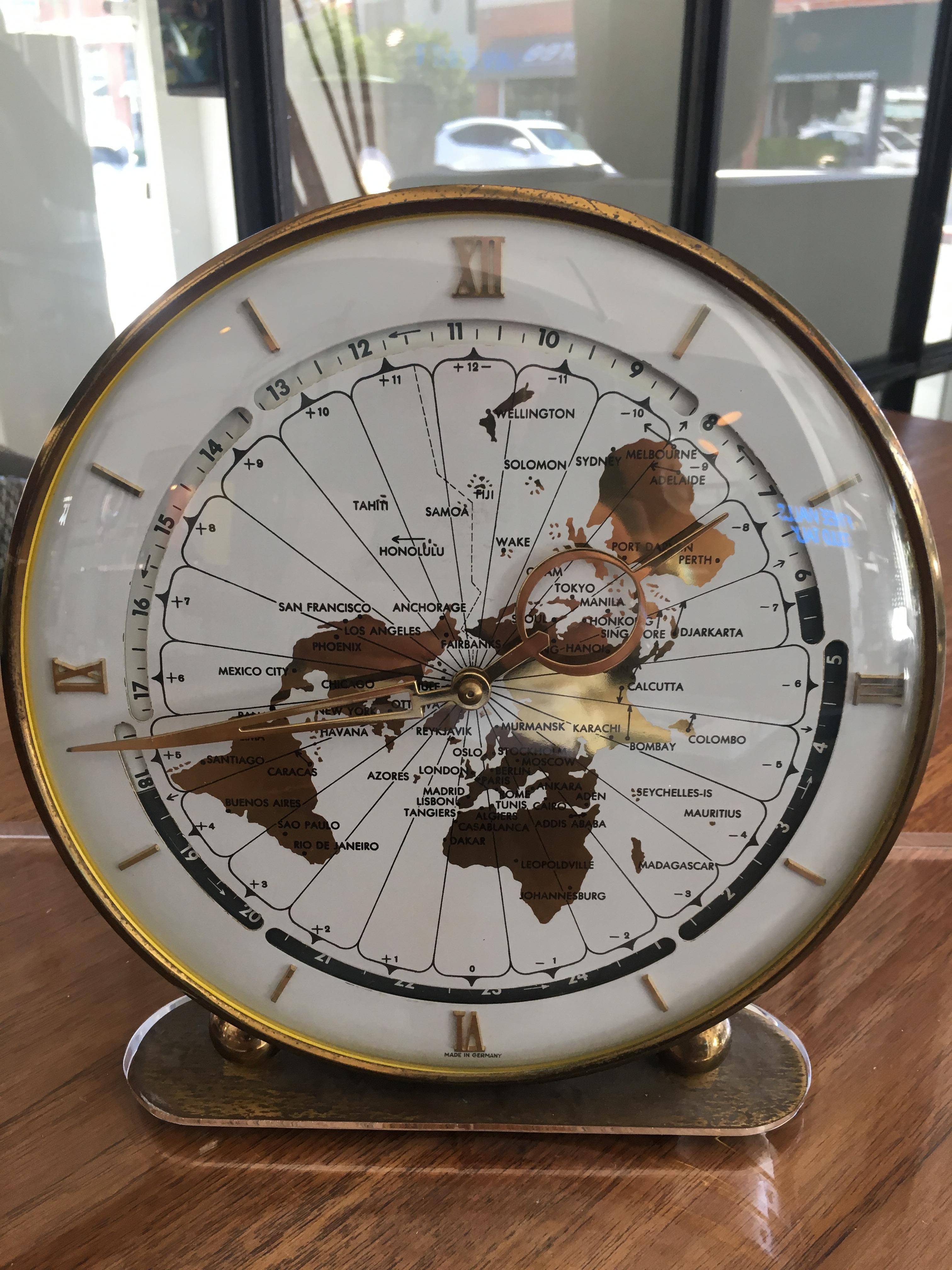 World table clock in brass with lucite base. In great working condition with winding mechanism in the back. The clock without the base is 9