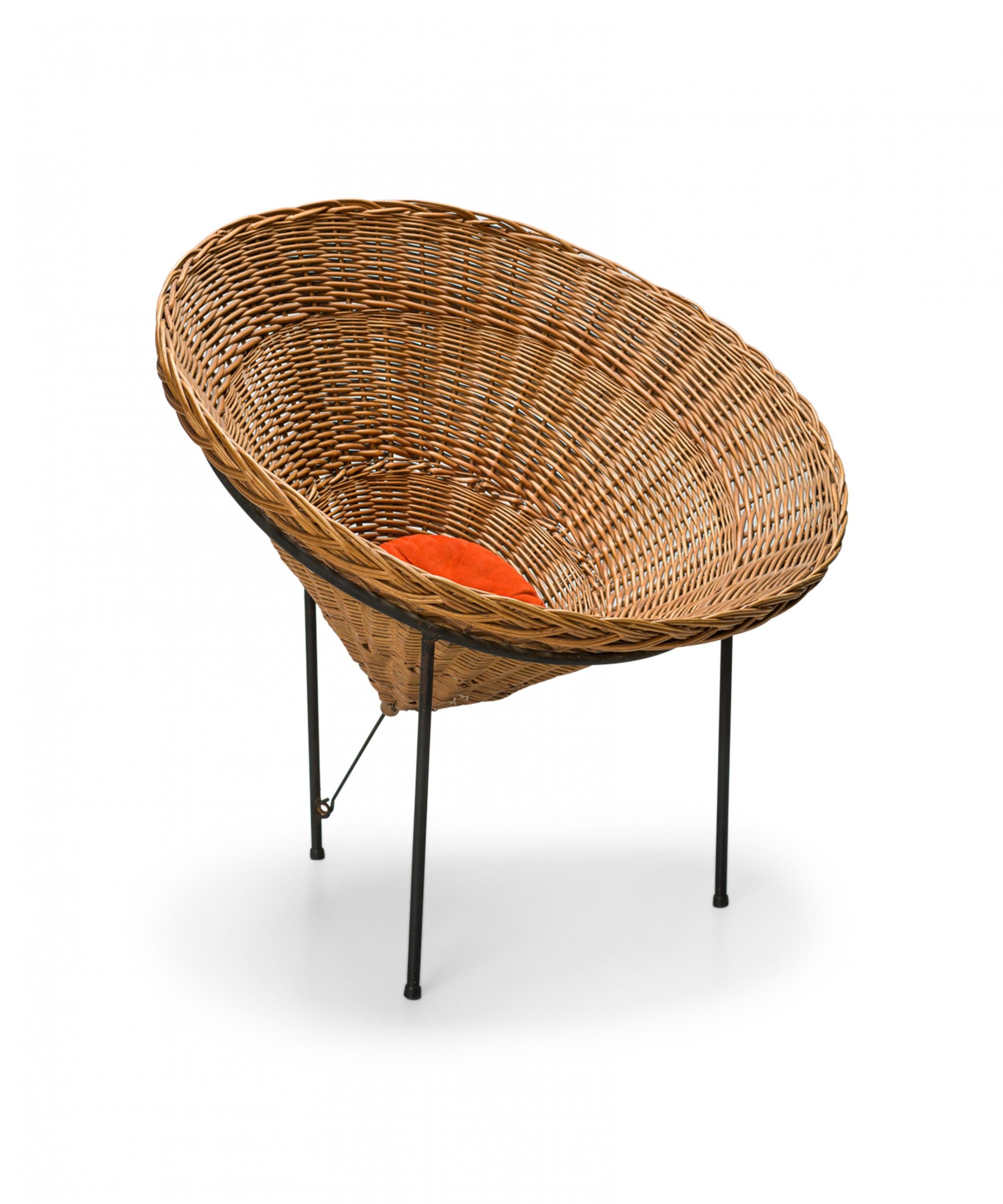Italian mid-century basket chair with a conical form, supported by three iron legs with a small orange cushion.