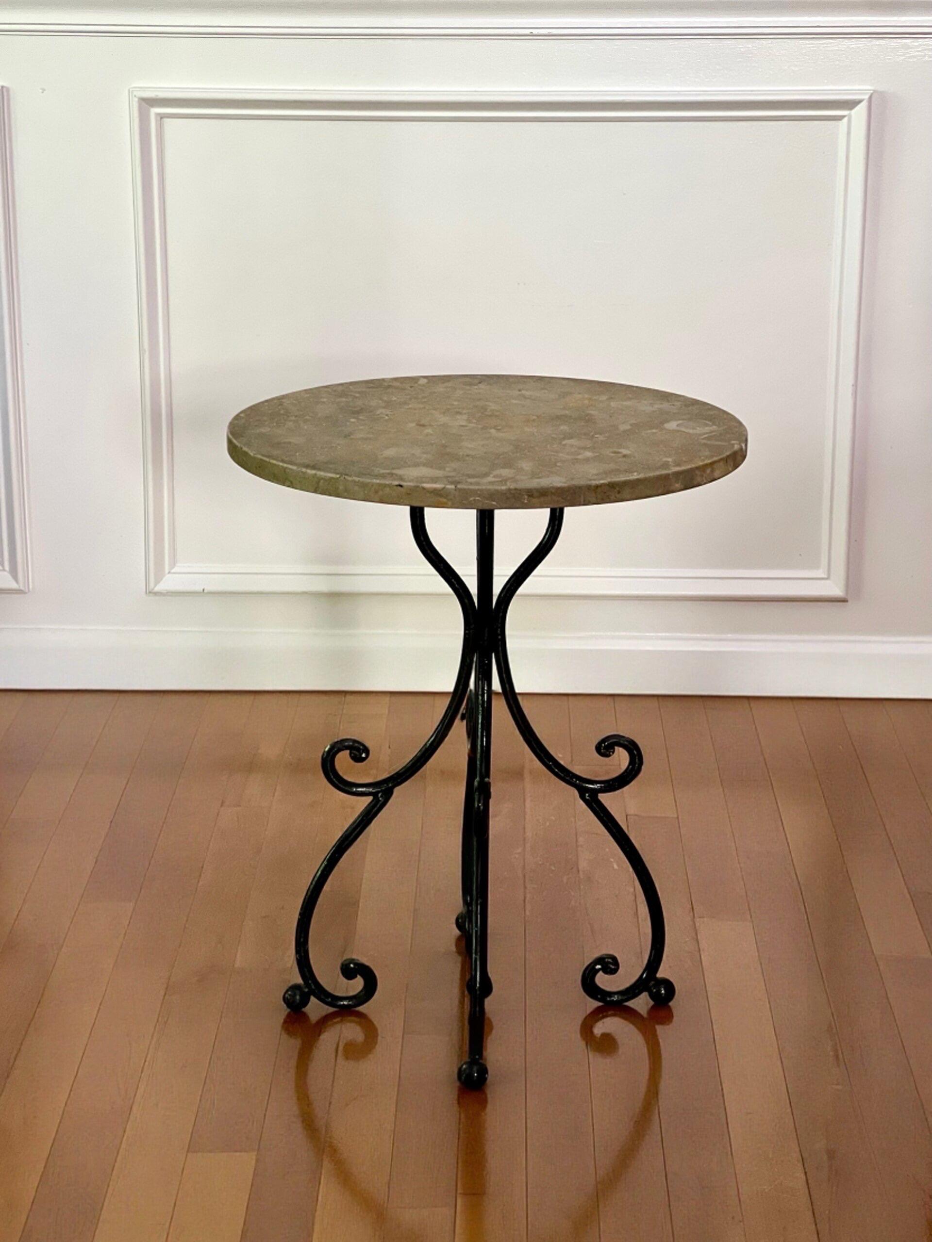 Wrought iron base side table with a travertine stone top, Italy, late 20th century.  A gray and tan stone top with a natural finish rests on a beautiful form scrolled black iron base.  Great for indoors or on a porch/terrace.  