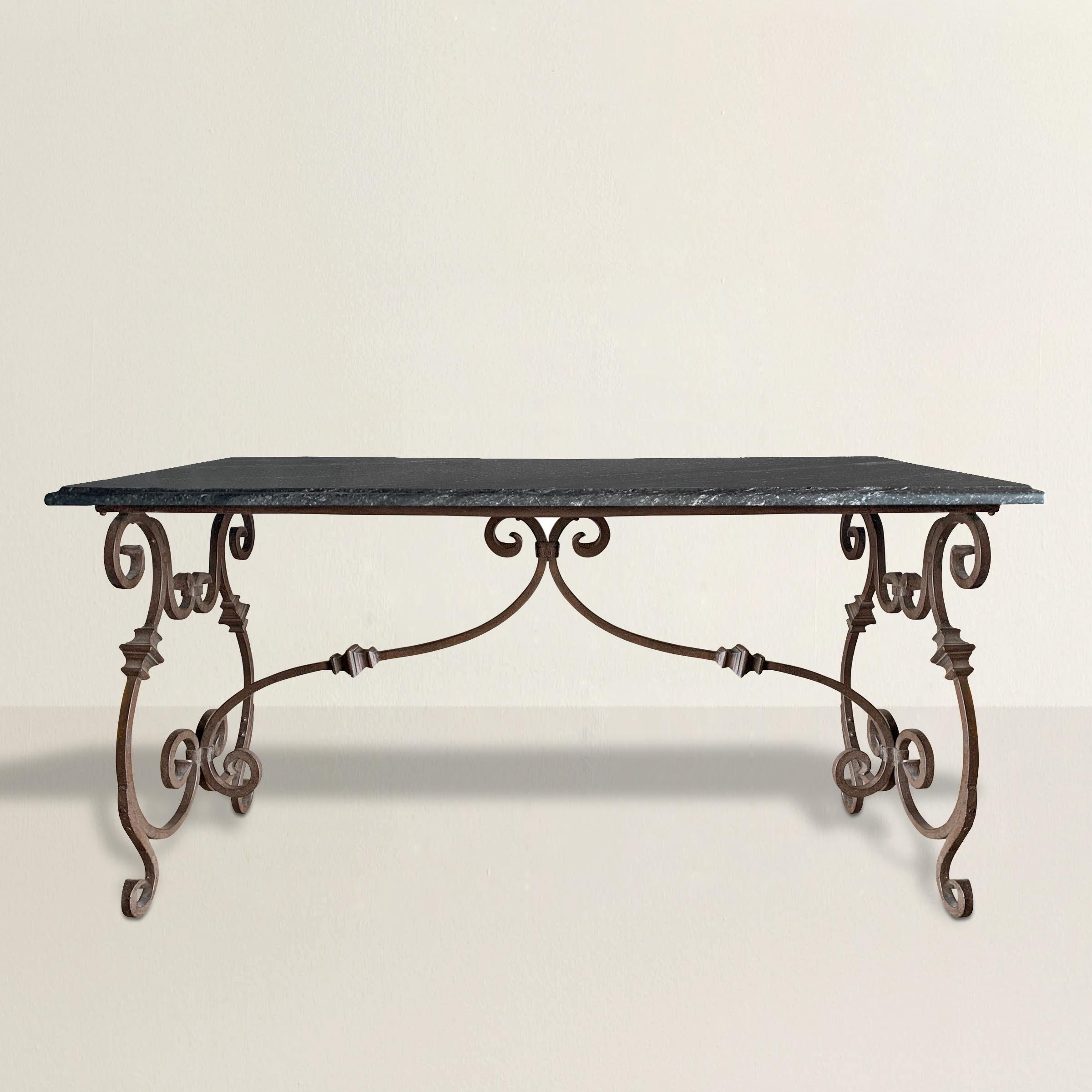 This late 20th-century Italian hand-wrought iron table is a sculptural beauty, marrying classical form with artisan craftsmanship. The iron base is hand-hammered and forged, showcasing the maker’s skill through exaggerated scrolled legs and two