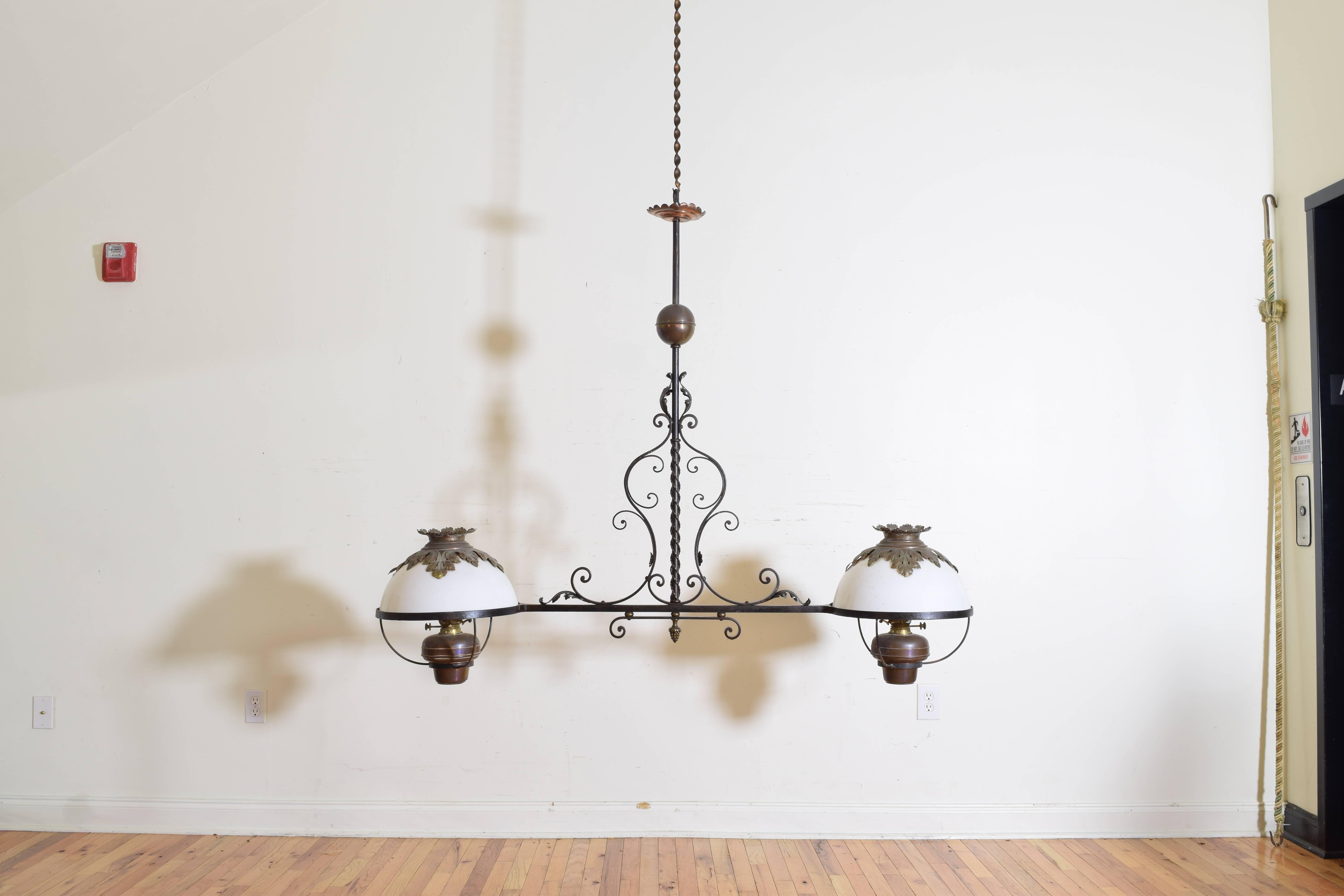 Fitted with oil lamps and original glass shades the wrought iron frame surmounted with copper and brass accents.