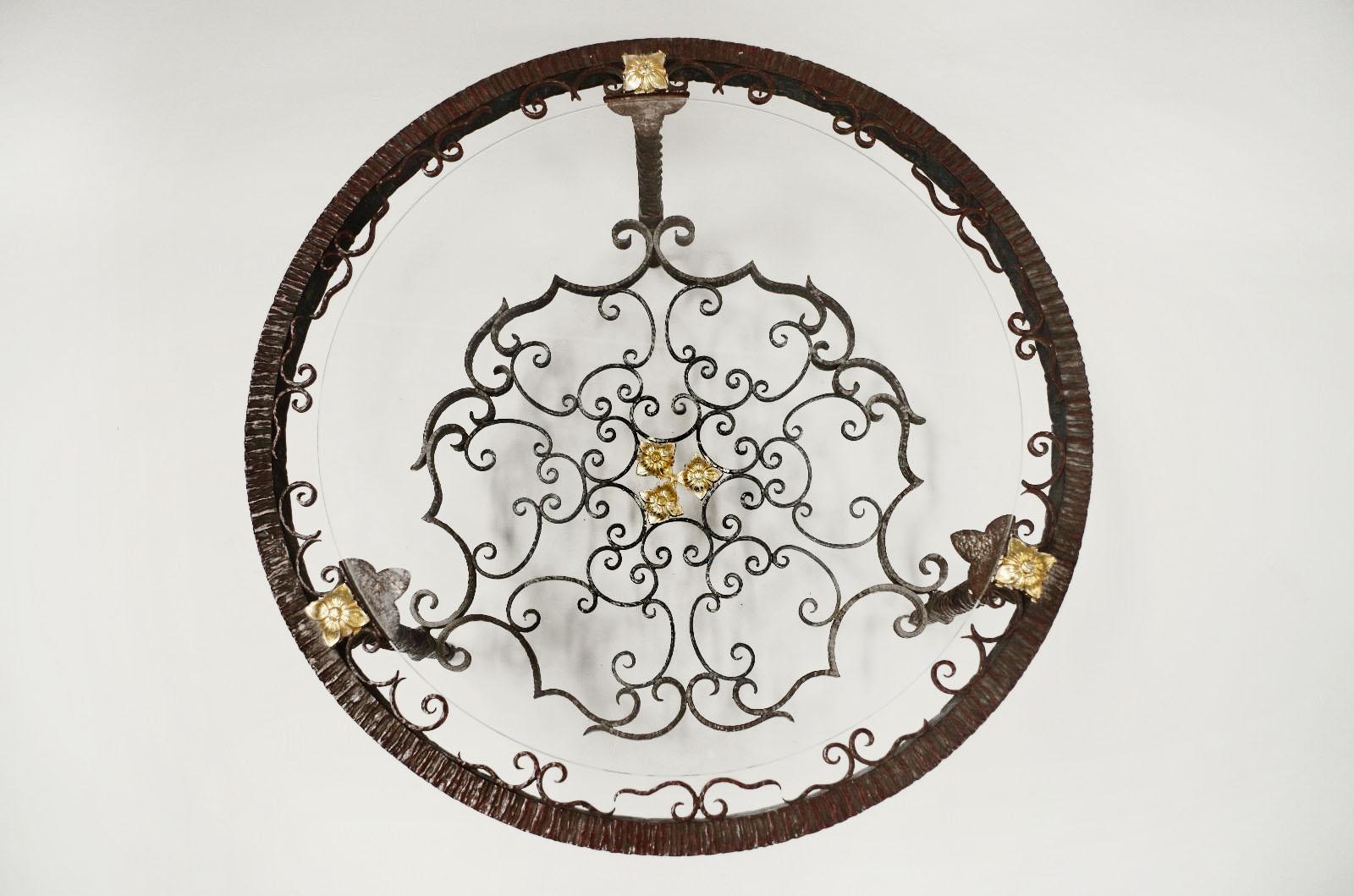 Round coffee table end wrought iron decorated by volutes and gilt rosettes. Twisted legs joined by a stretcher with the same decoration. Glass top.
Italian work, circa 1950.