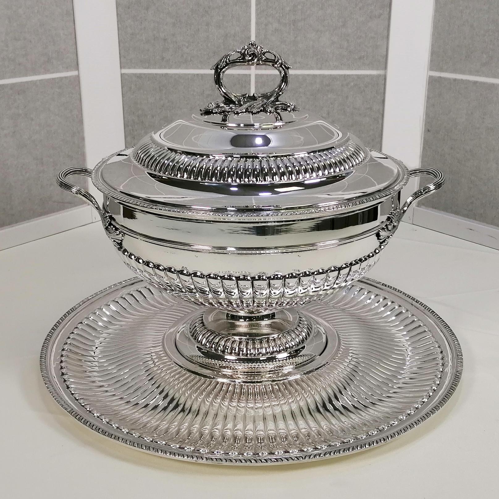 Large tureen with stand in sterling silver in Queen Anne style.
The round dish is embossed with a rounded striped design. The center of the plate has been raised as a cantilever where the tureen will be placed. The center of the stand was made