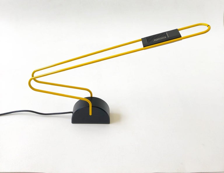A beautiful 1980s Italian yellow and black Postmodern desk lamp. The lamp has a high-low switch and it takes a small halogen light bulb. 

Dimension: 25” diameter 3” wide 16.5” high.