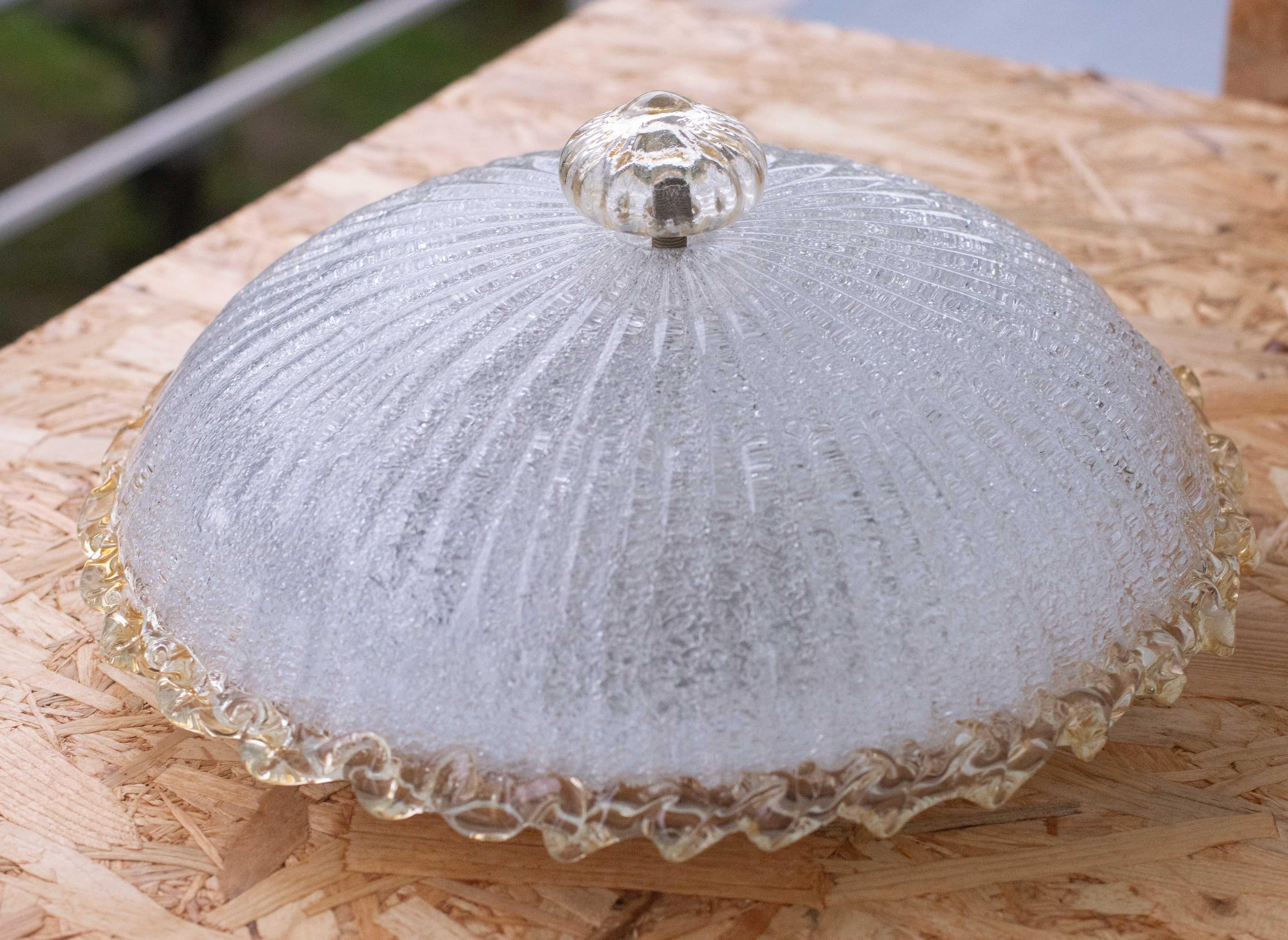 Stupenda plafoniera di Murano di colore giallo e trasparente/argento.
La plafoniera è composta da due elementi in vetro, la piastra centrale e l'elemento basso giallo.
Il piatto centrale è circondato da una striscia gialla ondulata tipica della