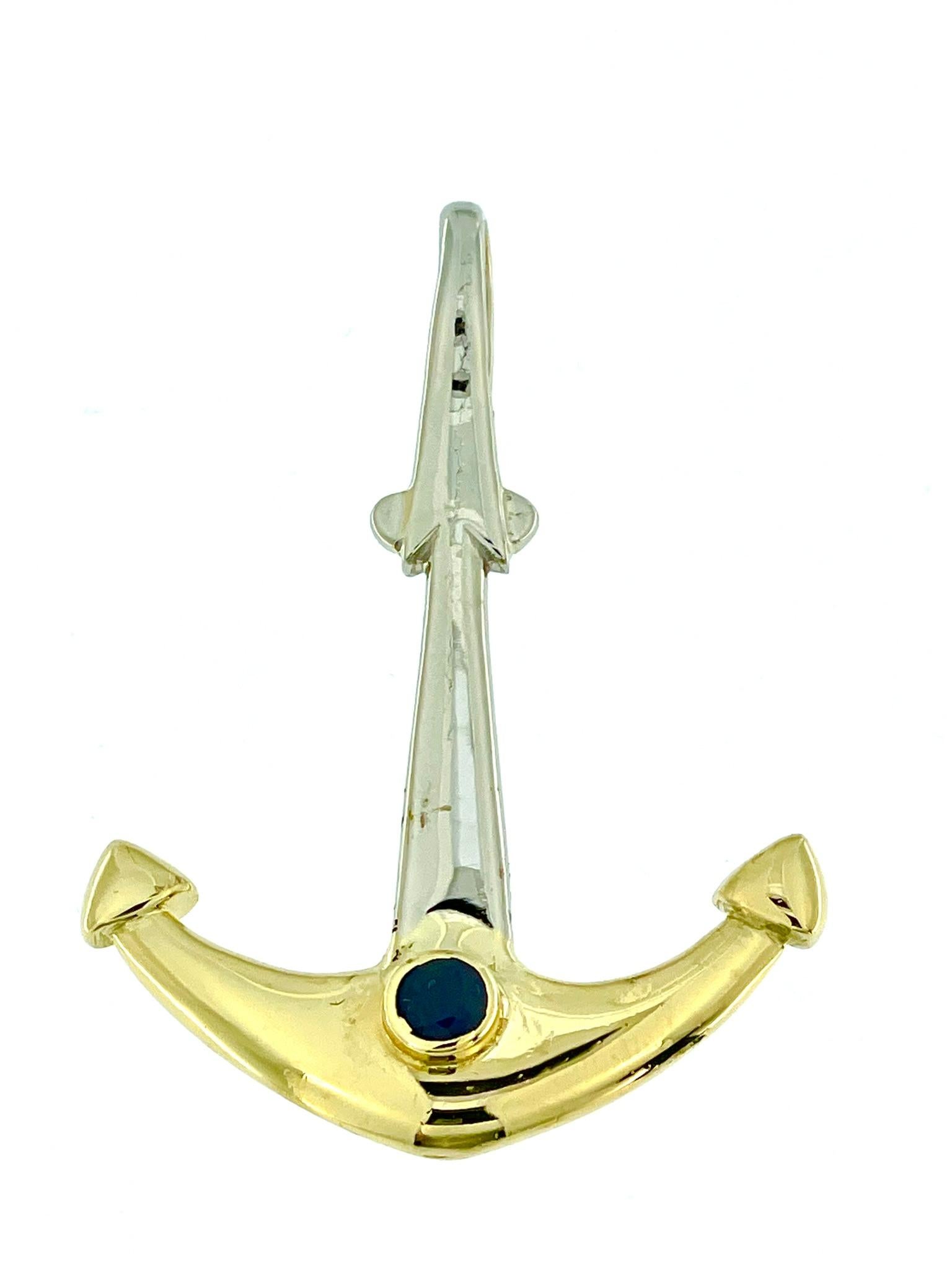 The Italian Yellow and White Gold Anchor Pendant with Sapphire is a striking piece of jewelry crafted with precision and attention to detail. This pendant is made from a combination of 18-karat yellow and white gold, showcasing a beautiful blend of
