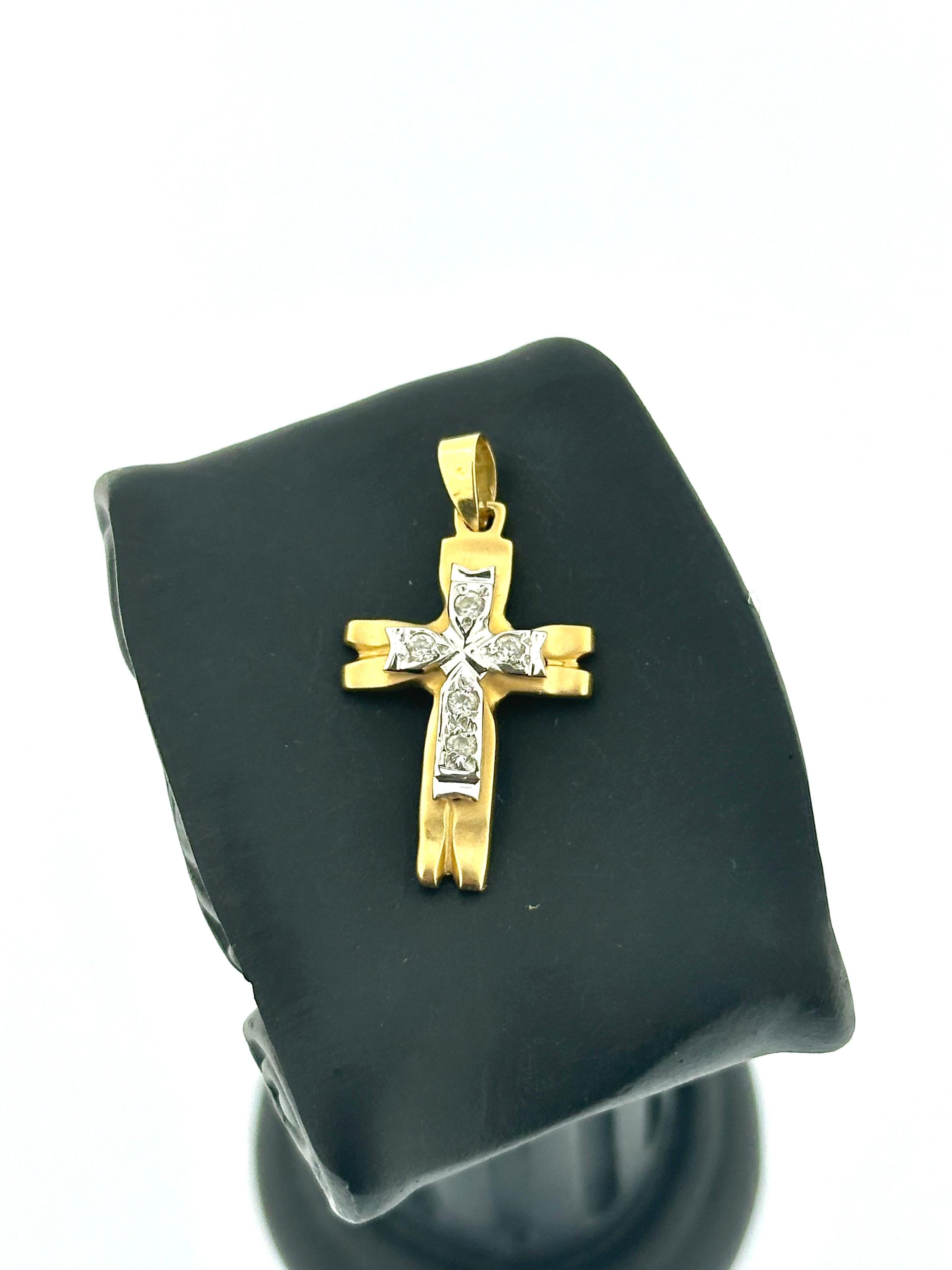 This Italian Cross Pendant is a beautifully crafted piece that exudes sophistication and subtle elegance. Made from 18kt yellow and white gold, it features a distinctive cross-on-cross design that adds depth and visual interest to the piece.

The