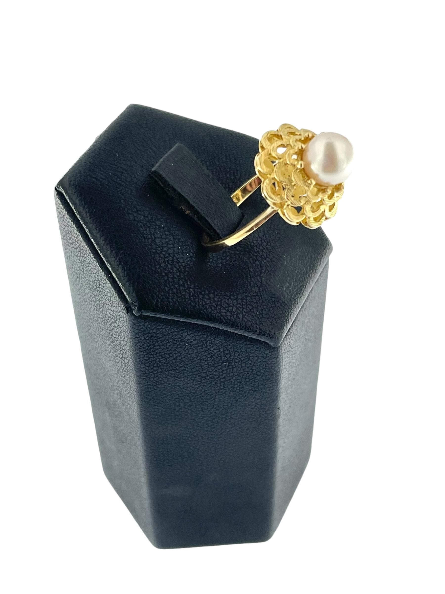 La bague solitaire en or jaune italien est une pièce élégante réalisée en or jaune 18 carats, avec en son centre une superbe perle blanche sertie. Conçue avec un délicat motif de fleur encerclant la perle, cette bague respire l'art italien classique