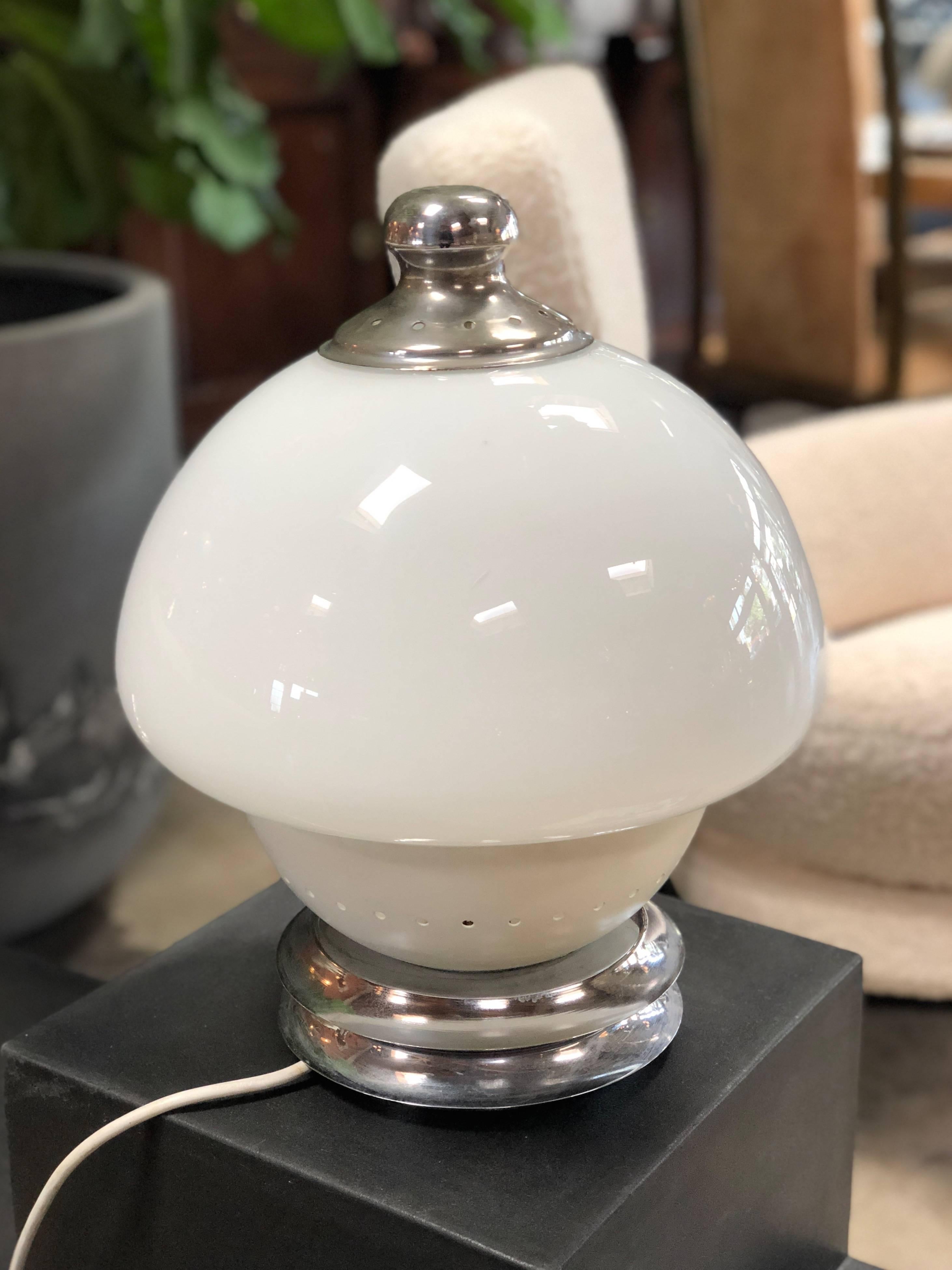 The uniqueness of this chic item is the shape of the dome of the lamp: one part in white milk glass and the bottom part in white metal. Has a chrome metal base.