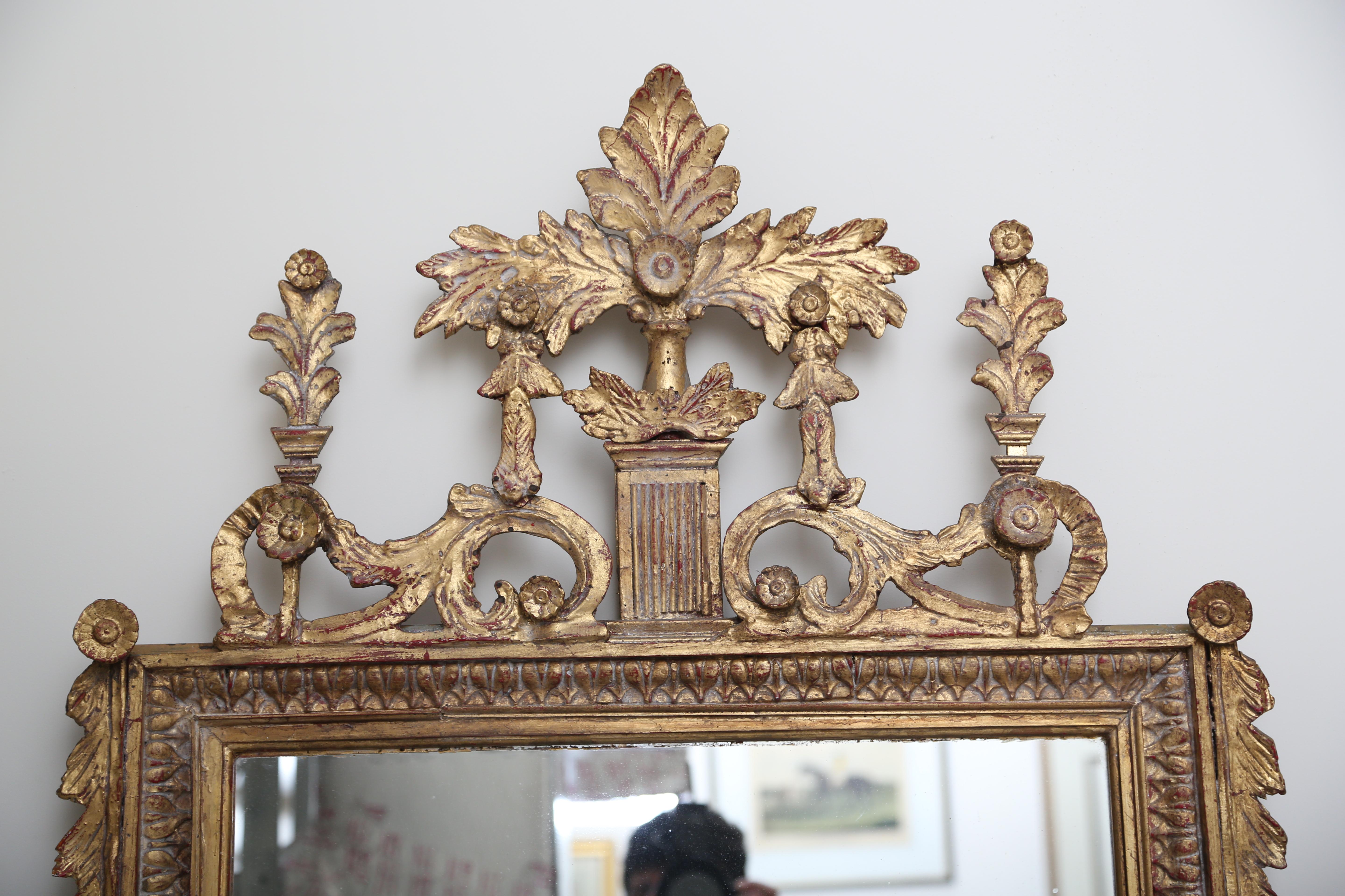 Carved and gilt Italianate mirror embellished with the flourishes of neo-classicism.  Shows evidence of hand craftmanship.  Ideal for over a mantle or as a wall mirror.
Height-68