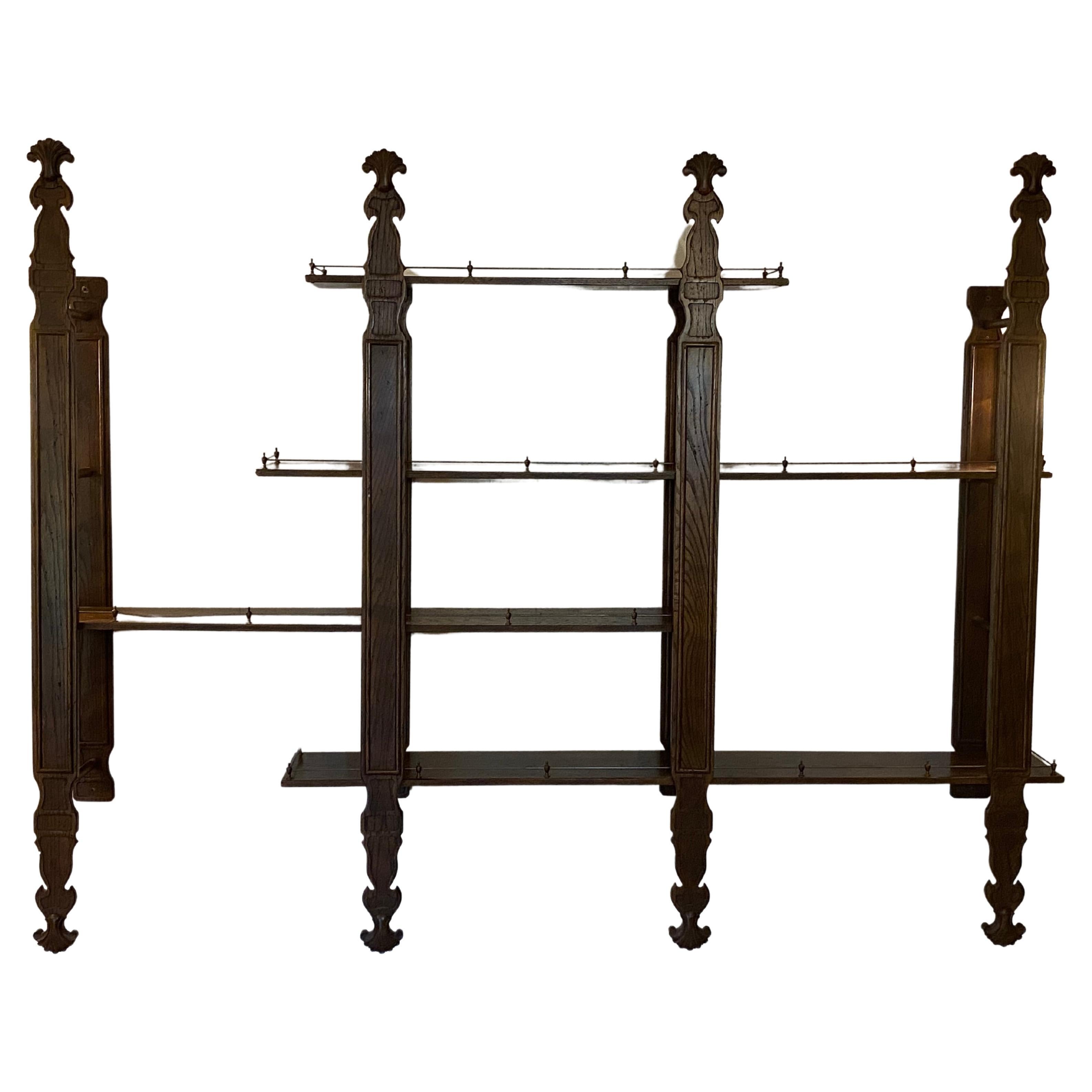 Carved solid oak shelving with brass galleries. Circa 1970. Wall mounted with four vertical brackets. Each shelf can be horizontally adjusted to your specific taste or specifications. Each shelf is loose mounted on top of the horizontal dowel. The