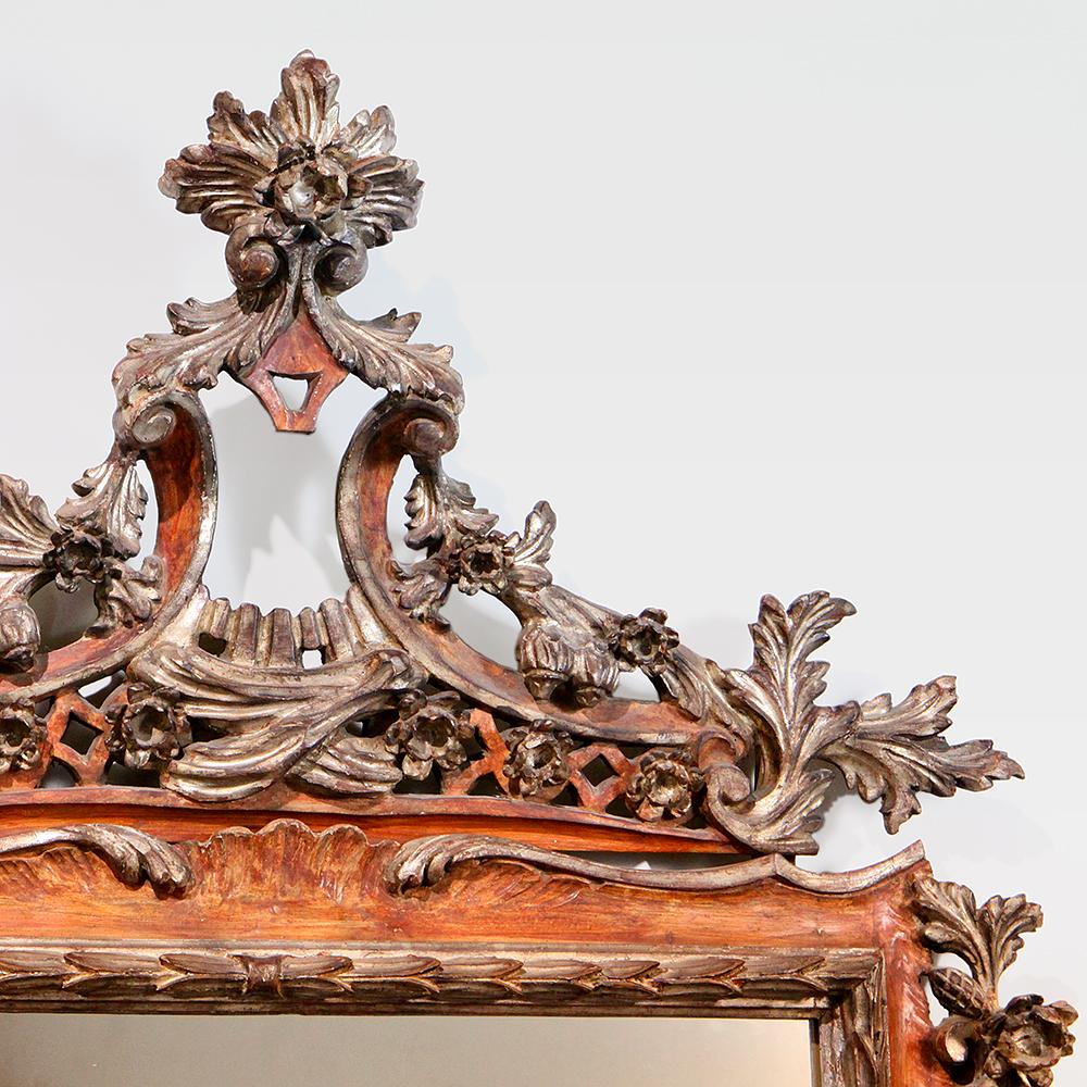 Striking Victorian Italianate style mirror in red and gold tones with detailed scroll and leaf pattern.  Ornate floral pattern carved with a combination of gesso, gilt and painted design elements.