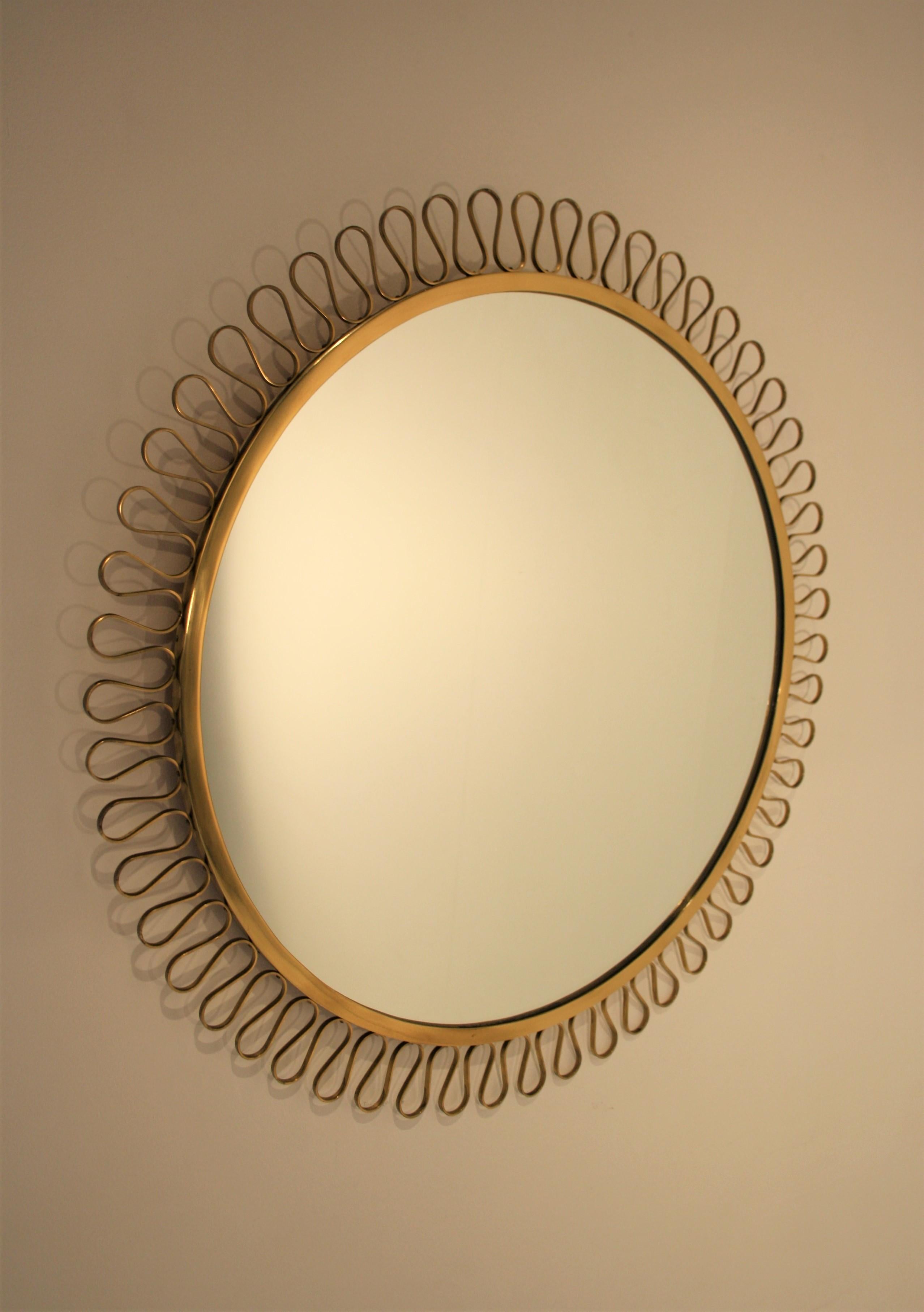 Beautiful Italian handmade brass mirror in the style of Gio Ponti from the 1950s.
A very fine quality and a beautiful craftsmanship, especially the way the decoration was attached around the mirror and also its shape made entirely from one piece.