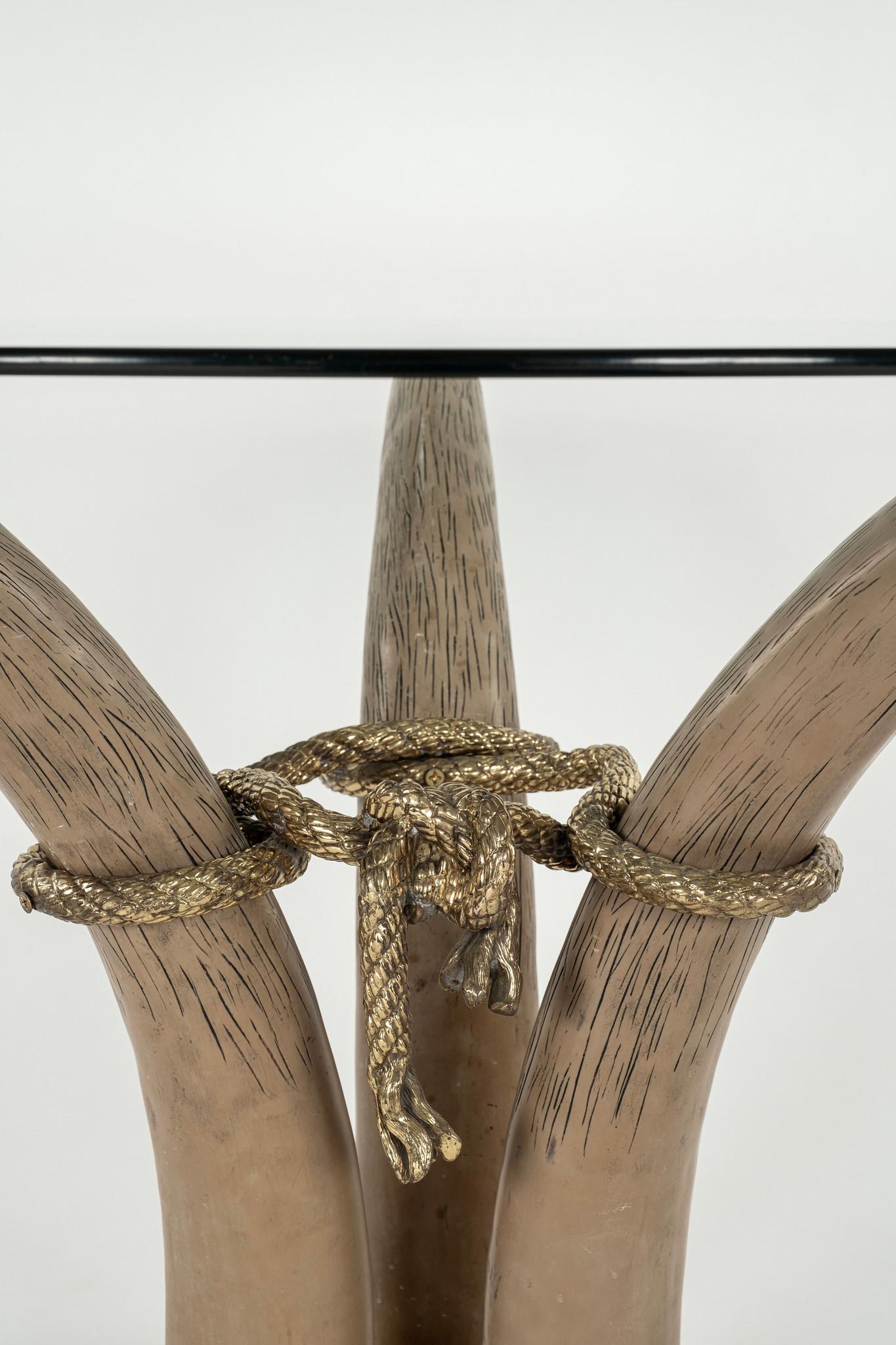 A chic and stylish 1970s faux tusk center or occasional table manufactured by Spanish luxury brand Italo Valenti.  Three mocha toned faux resin tusks tied and supported with gilded bronze rope and foot detailing.

Dimesions:
26.625”H x 37.5”D base,
