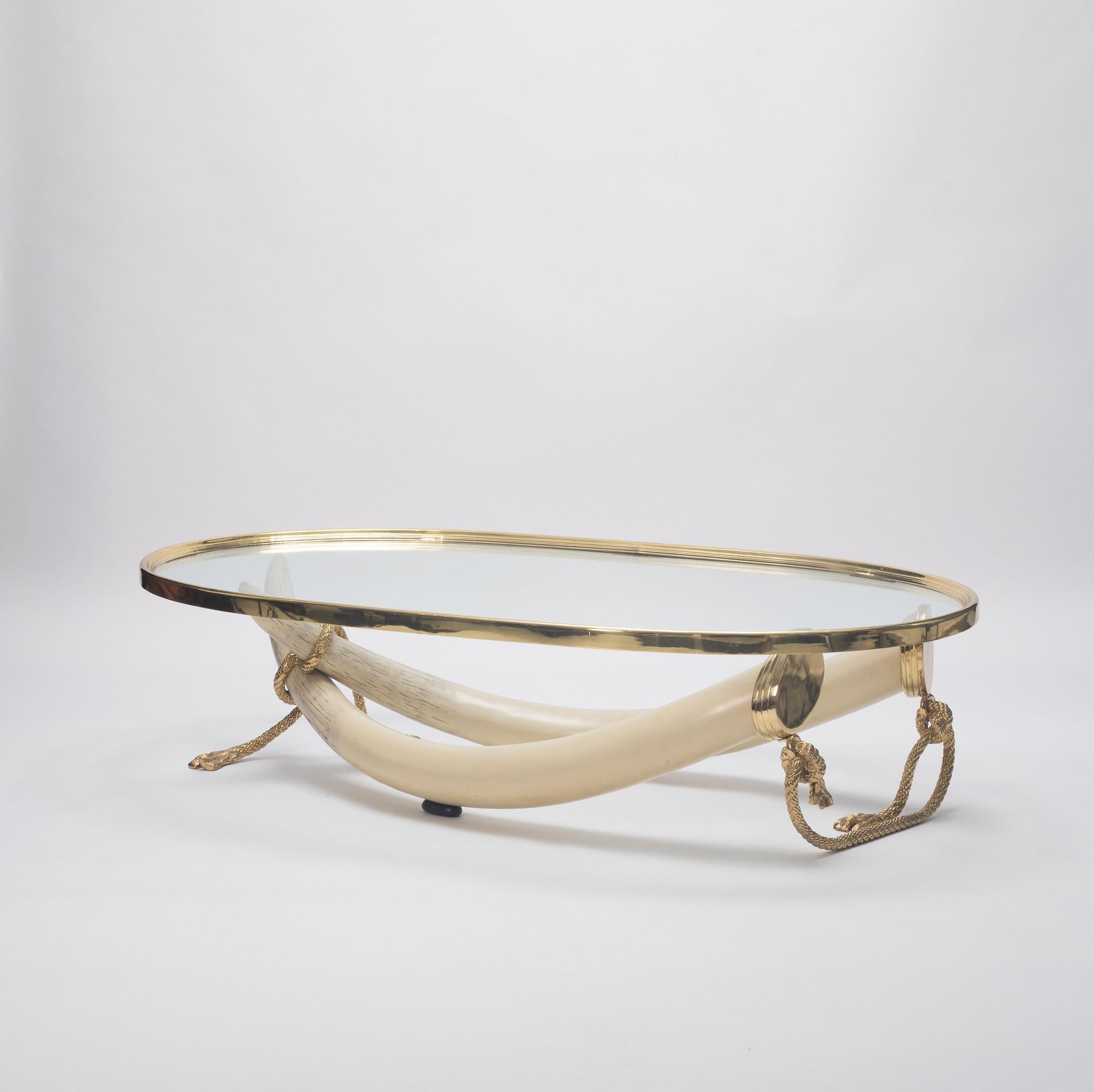 Designed by Italo Valenti, this exquisite cocktail table is a stunning example of mid-20th-century luxury furniture. The table features a unique faux tusk  base crafted from resin wrapped in gilt bronze rope, all  supporting an oval glass top