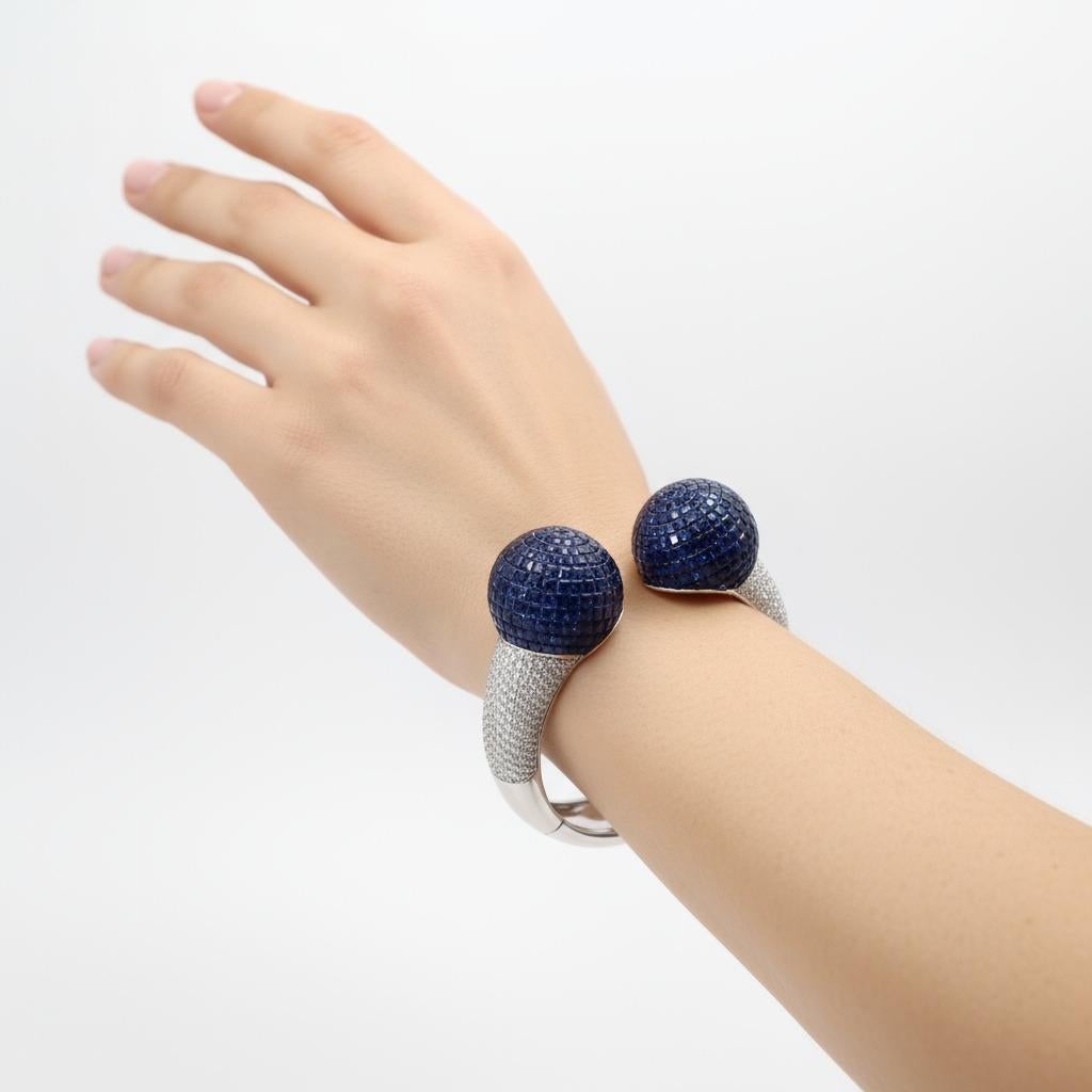 Questo straordinario pezzo contemporaneo rappresenta l'apice dell'arte gioielliera italiana, con un'eccezionale incastonatura invisibile di 497 zaffiri blu a taglio quadrato per un totale di 37,60 carati che creano superfici senza soluzione di