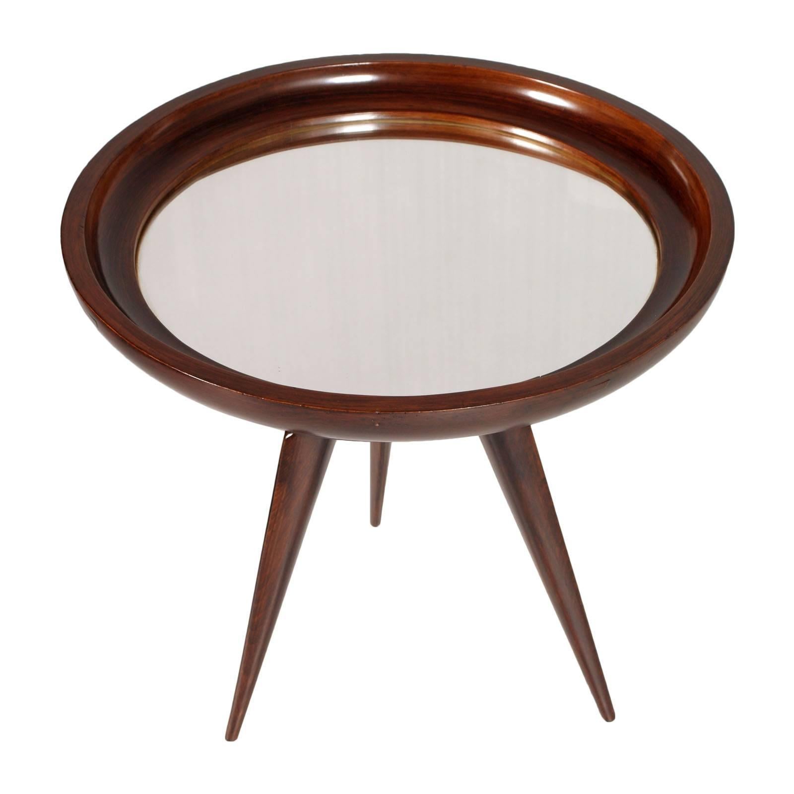 Rare awesome center coffee cocktail table in mahogany, Cesare Lacca attributed, with top mirror and gilt brass connections.
The style is reminiscent of the architect Oscar Niemeyer

Measures cm: Height 53 diameter 62.