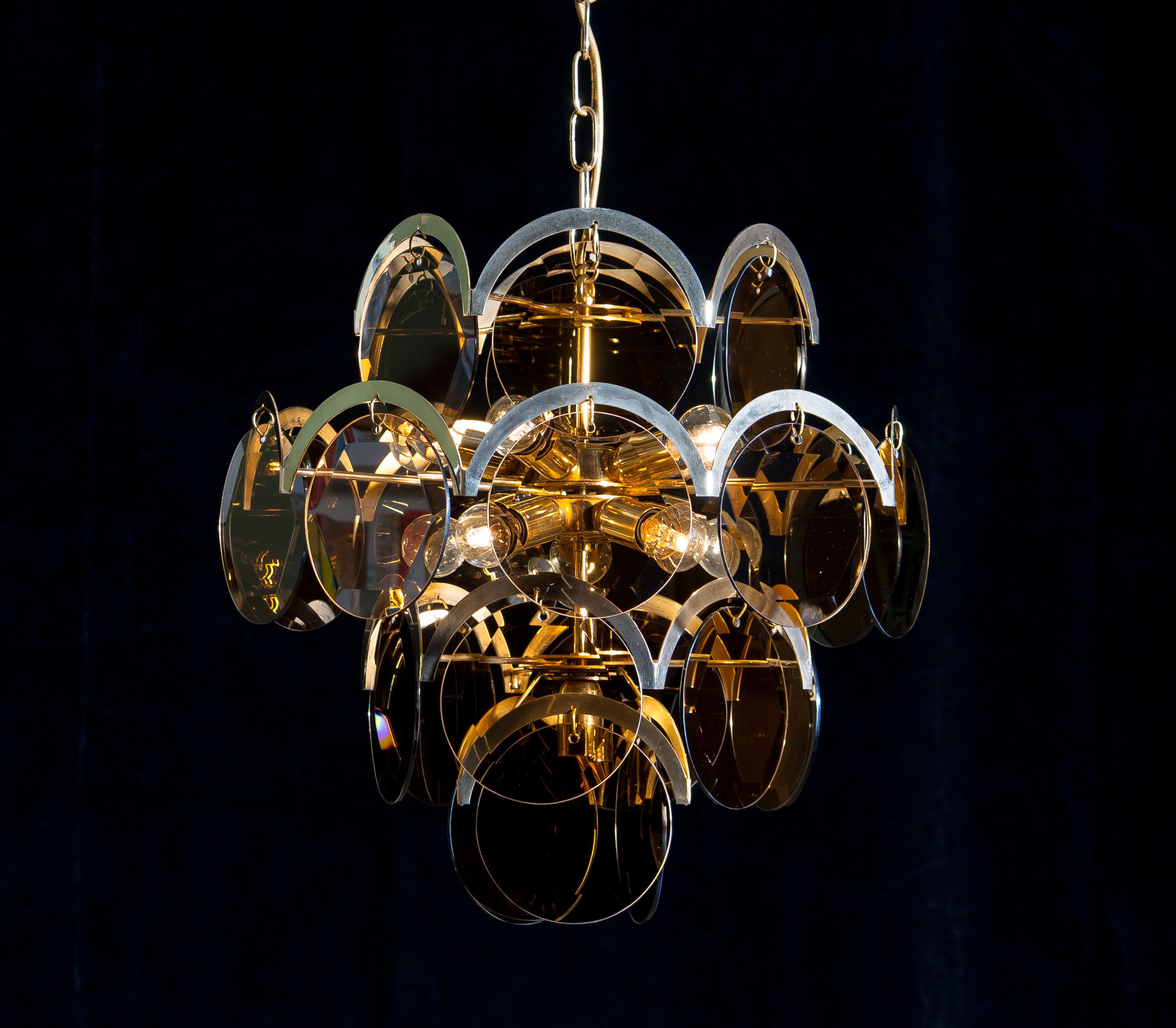 Beautiful chandelier in brass with twenty-four smoked (facet cut) hard glass discs by Gino Vistosi.
The chandelier is in good condition and contains ten fittings, size E14 /17.
Technically 100%.