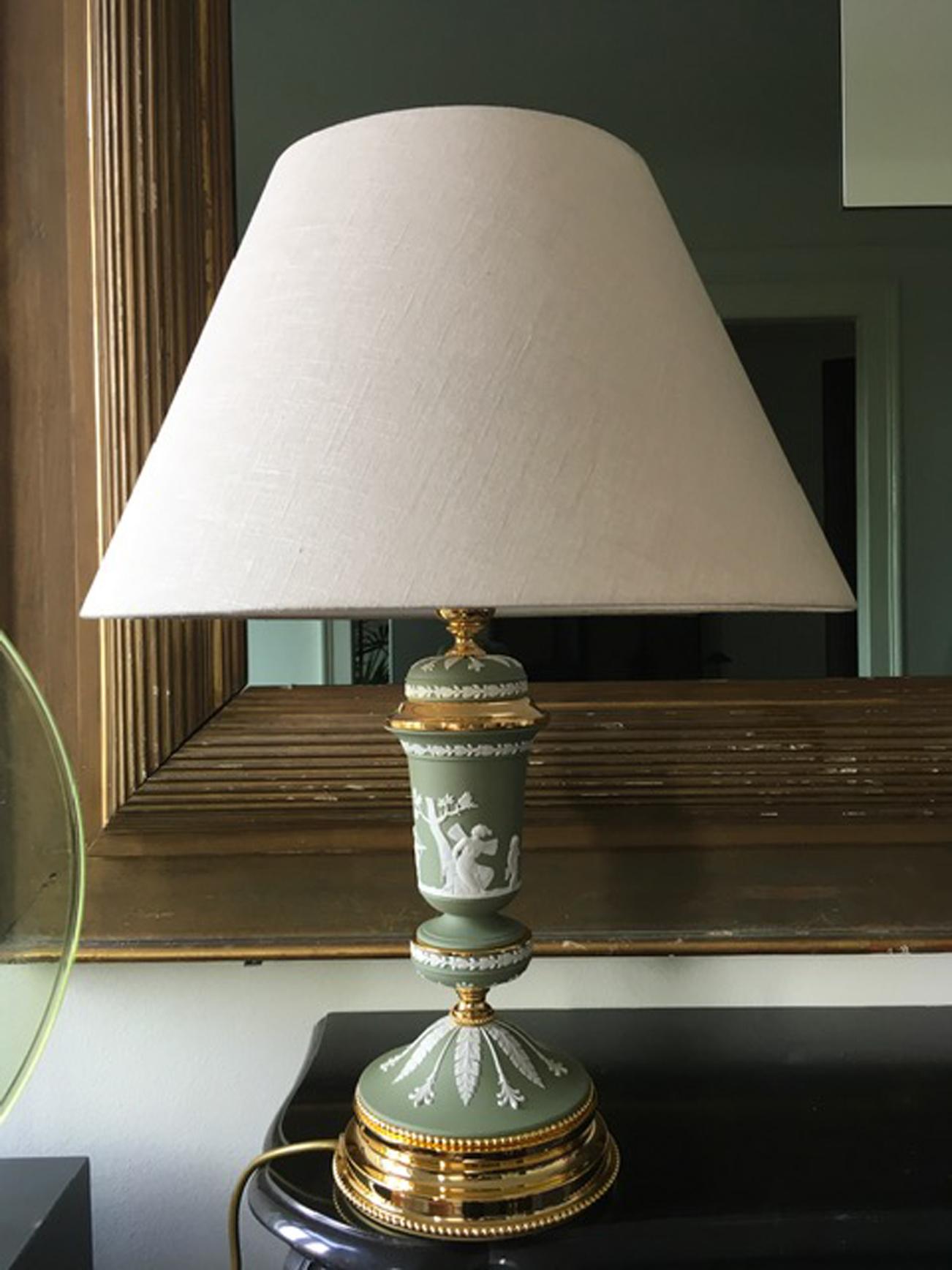 Cette lampe de table élégante et glamour en porcelaine vert clair et laiton, est l'une des dernières pièces fabriquées par une usine italienne bien connue  au cours des années 1970 et est resté en stock jusqu'à aujourd'hui. Les scènes grecques et