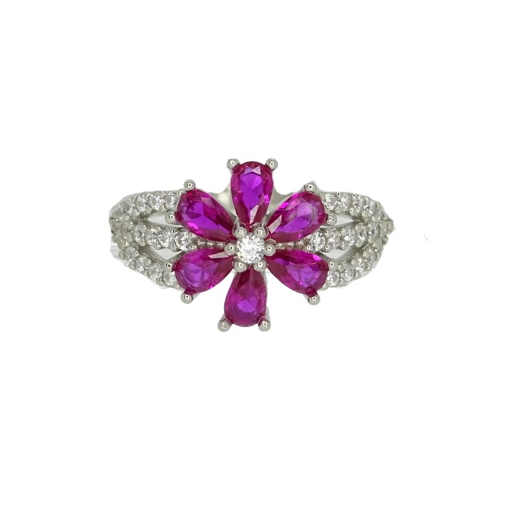 Gorgeous ring set in 925 silver. The shoulders of the ring are divided into three bands of inlaid cubic zirconia. In the center, a large flower takes center stage in this piece. It is composed of six pear-cut ruby ​​petals and a central cubic