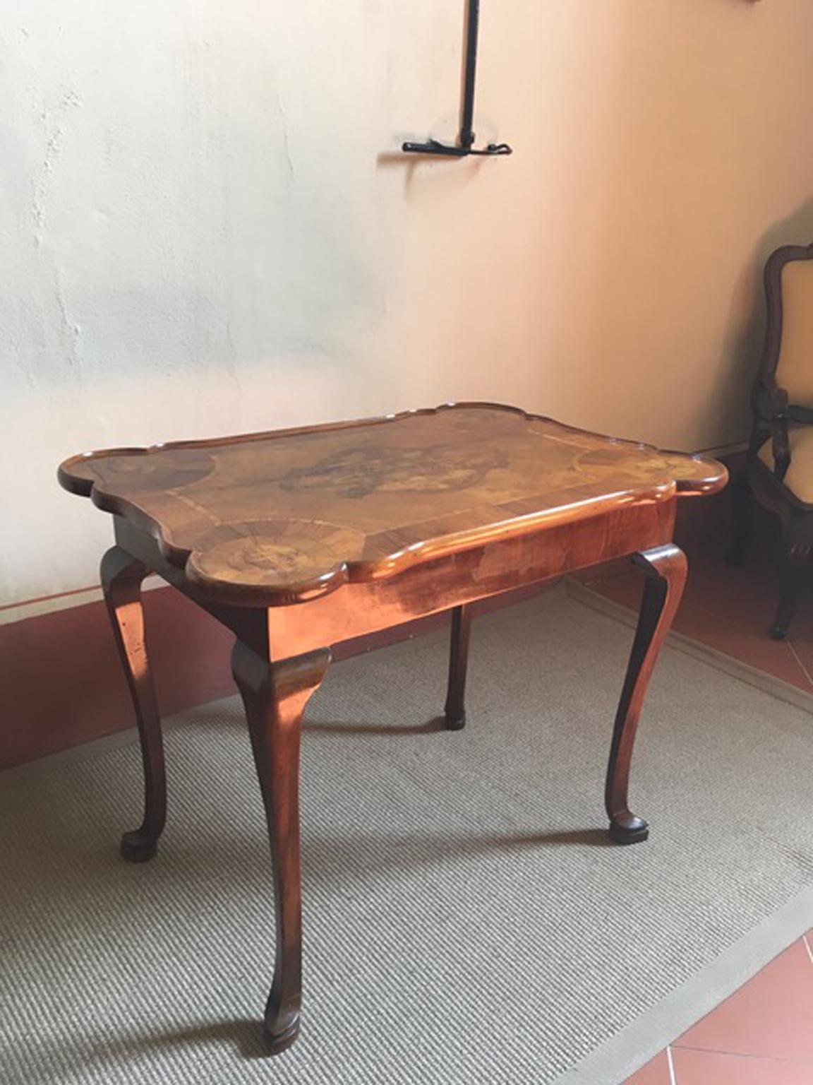 This is an elegant gaming table, hand made in the Late 18th Century by master craftmenships. The spectacular top of this charming table, is handmade in walnut with fine briar root  and pear wood inlaids. The different kind of woods, create the