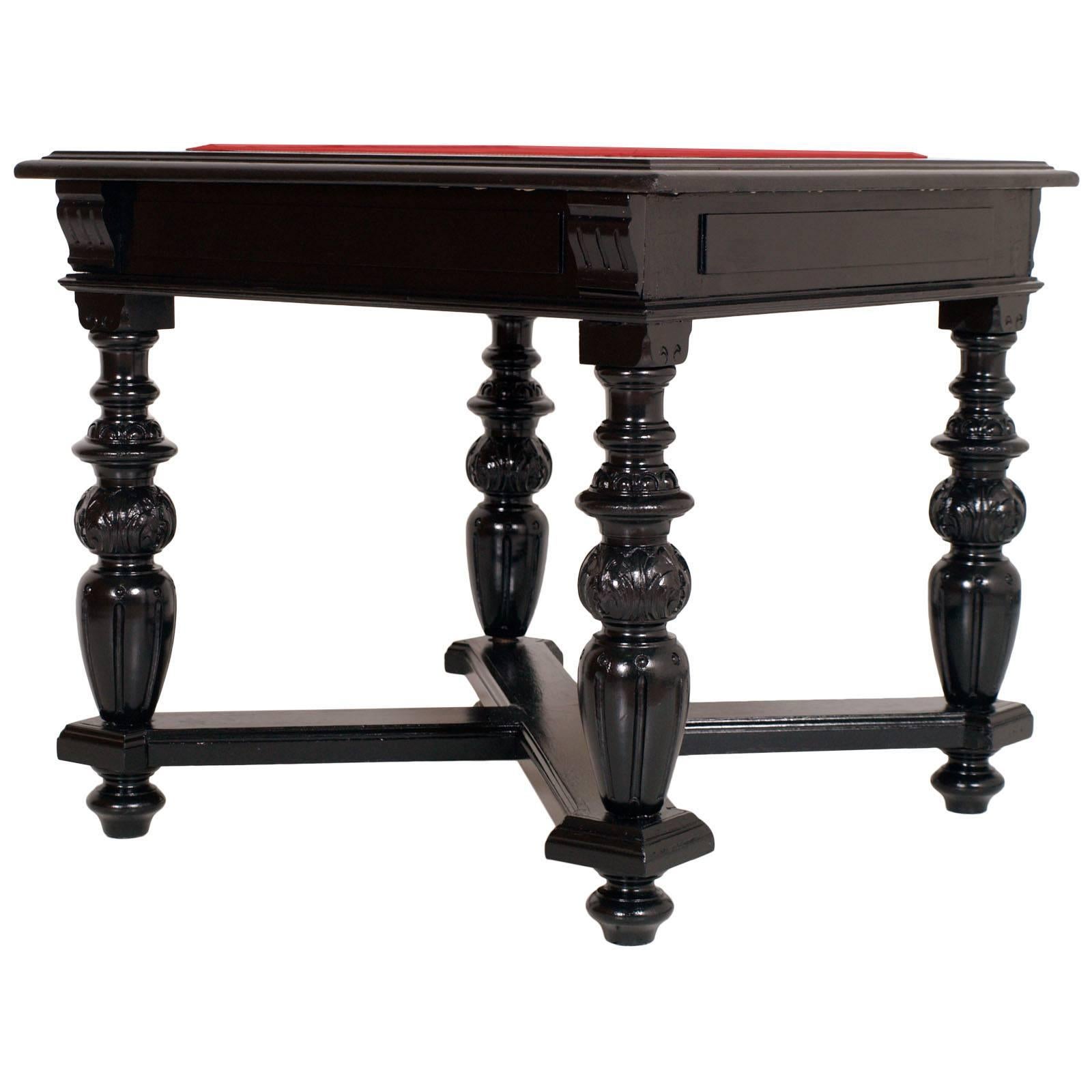 Tuscany antique neoclassical occasional or game table from the late 18th century. Solid ebonized walnut with turned legs and cross-shaped lower crosspiece. We made conservative restoration and re-upholstered the top with red velvet. Polished to
