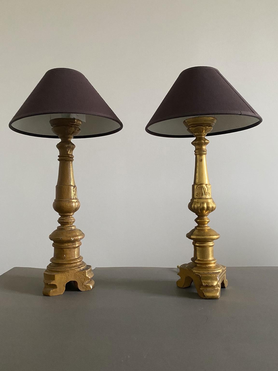 Se trata de un par de antiguos candelabros de madera dorada y tallada, se han montado como lámparas de mesa en la actualidad. Se trata de un elegante ejemplo del barroco de finales del siglo XIX. Las bases de madera tienen un anverso y un reverso,
