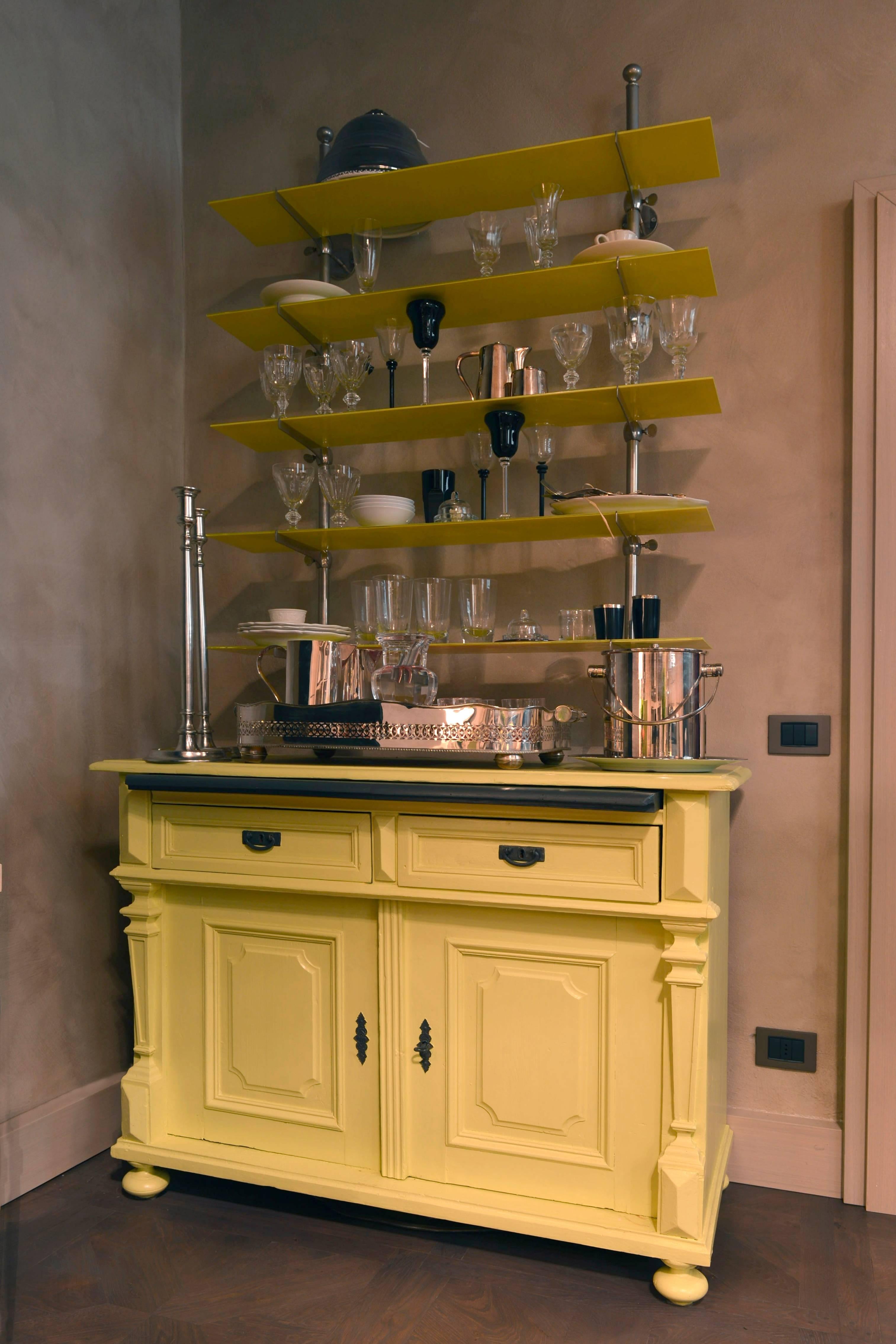 Italy Mid-19th Century yellow lacquered wood and glass shelves buffet in farmhouse style

This cheerful yellow wood lacquered buffet is composed by two part: the mid-19th  Century pine wood buffet, that it is  currently hand-lacquered in yellow