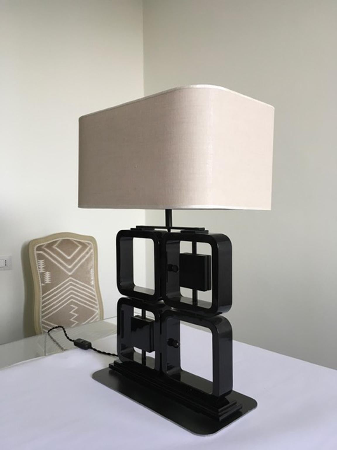 This pair of elegant and stunning table lamps are totally hand made in black laquered wood; this table lamps are a piece of high craftmenship, every square has hand made one by one following a well known shape designed by Osvaldo Borsani, an iconic