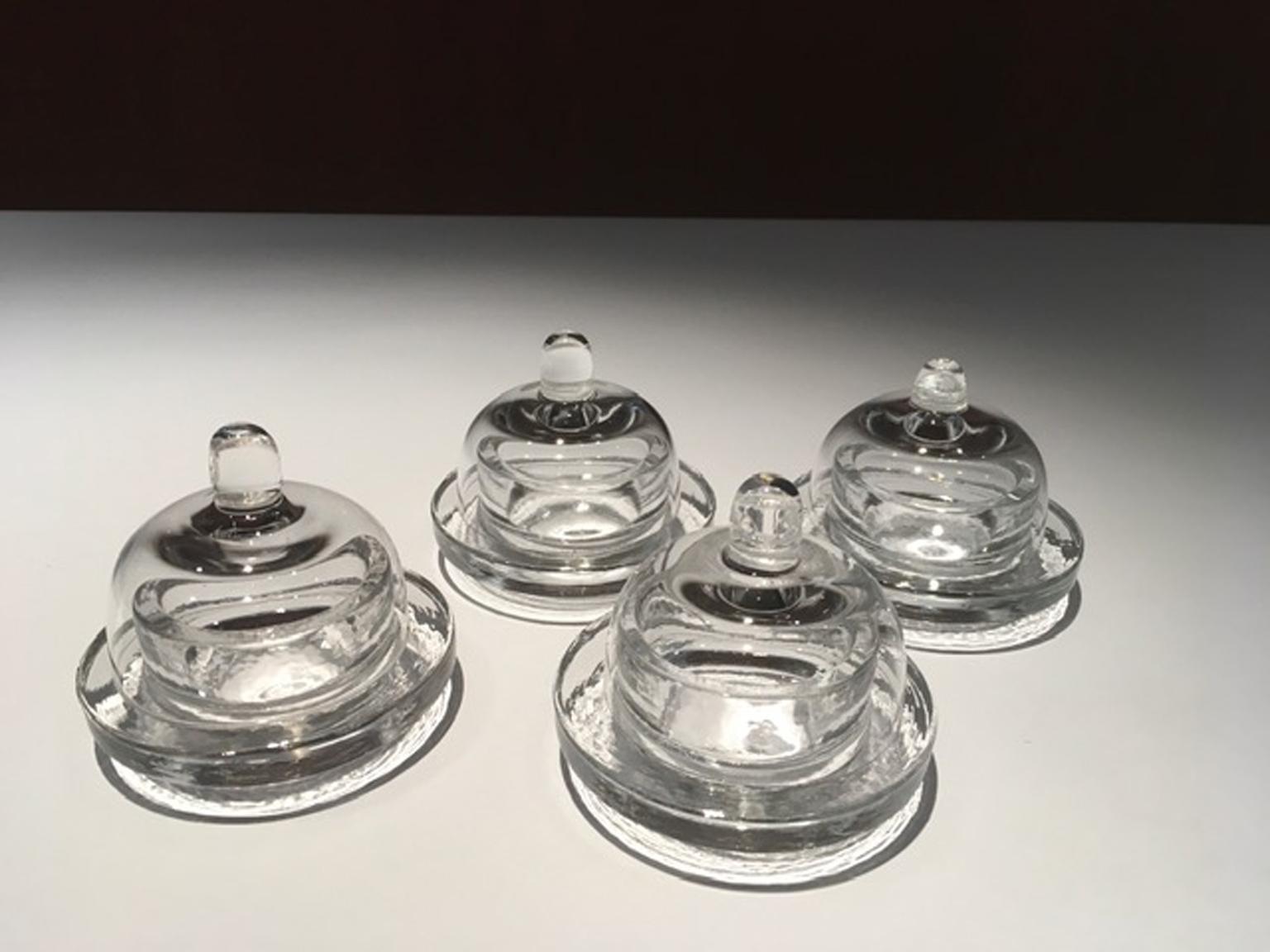 This is a glass butter dish set to be used to complete the table setting for an elegant dinner.
 