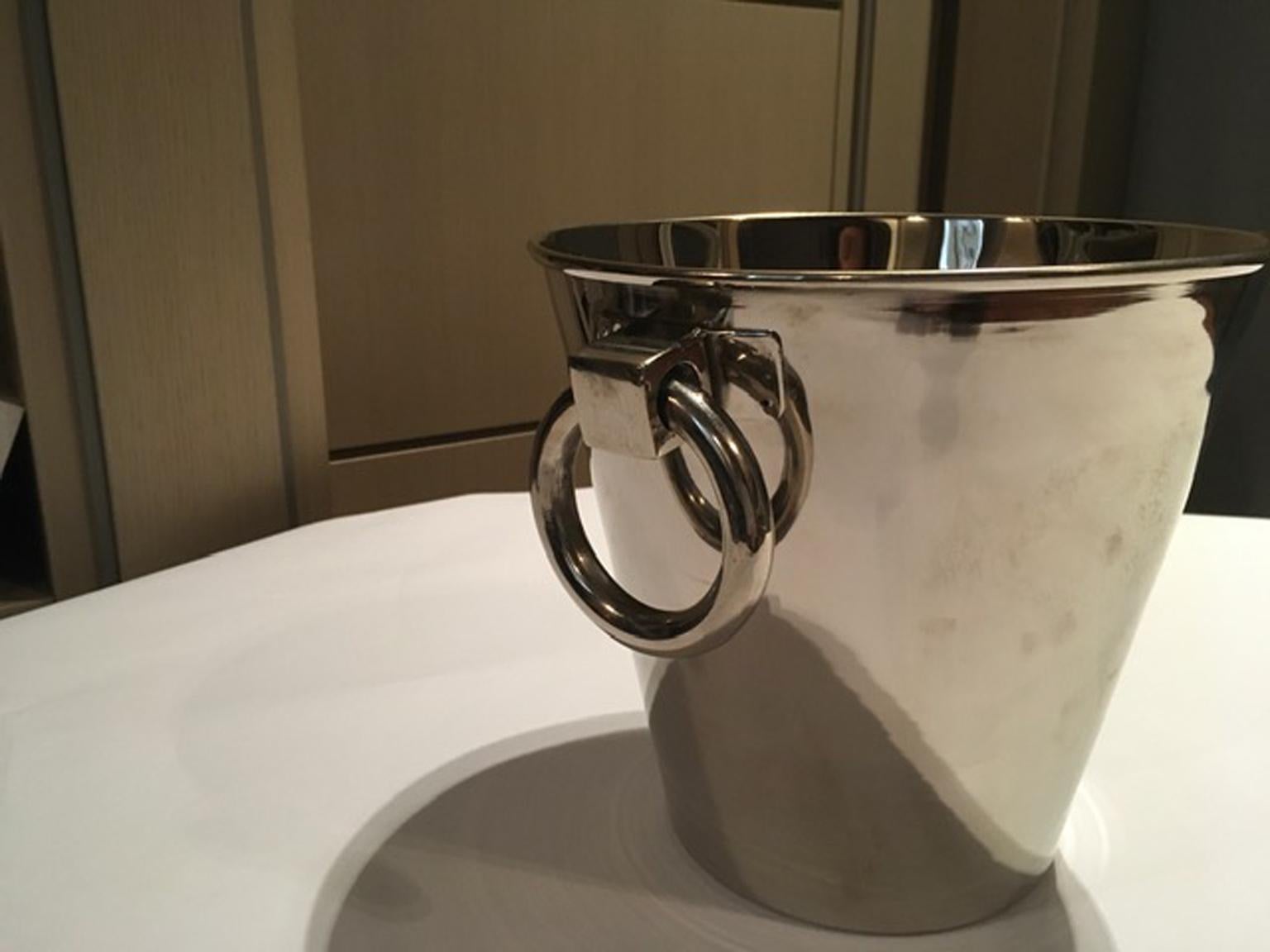 This elegant model of ice bucket is realized in silver plated metal. The contemporary Italian design add a plus at this piece. A pair of rings is a decorative detail useful as handles too.
