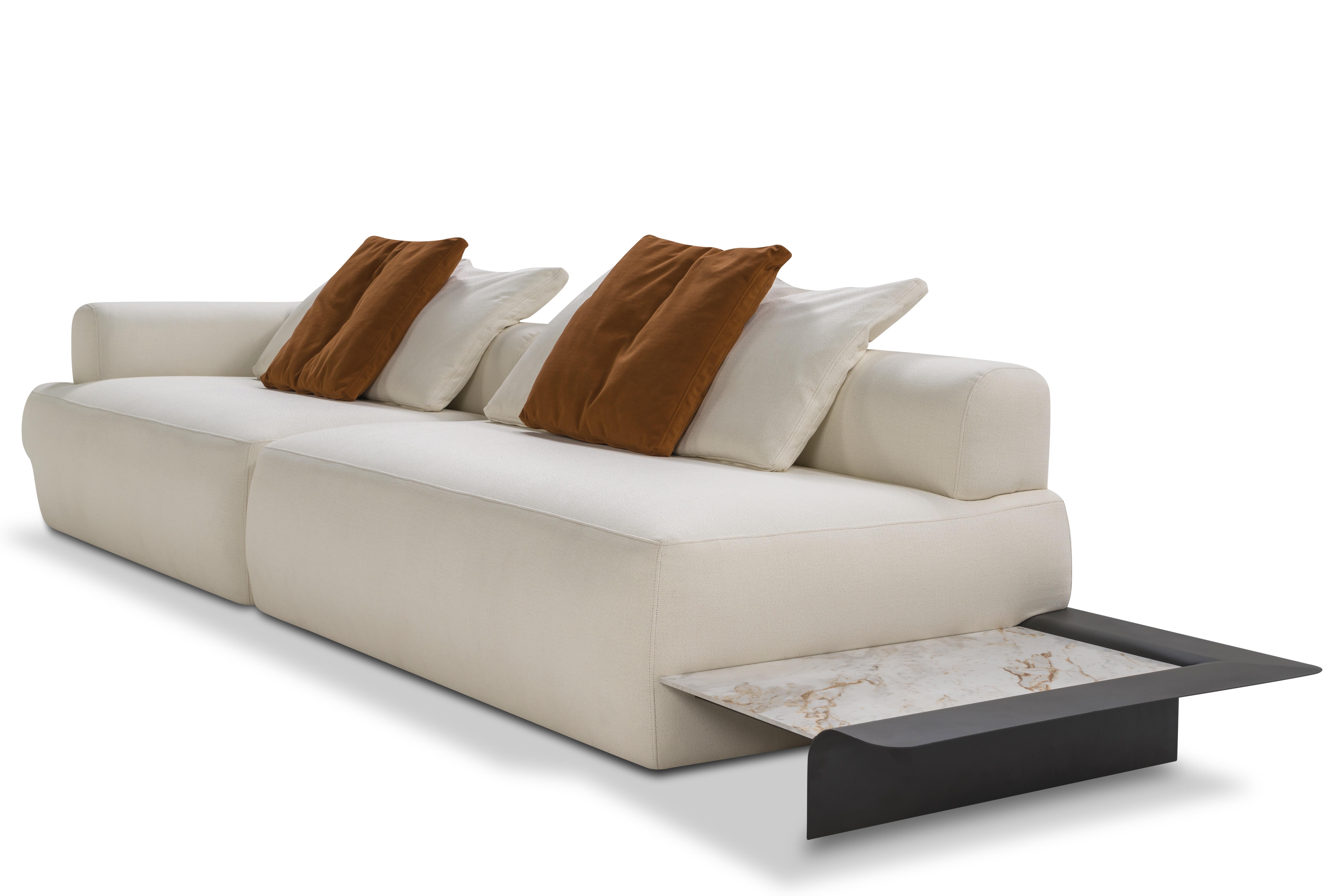 Designed with an elegant aesthetic, the model offers comfort and the functionality of being a sofa that incorporates a corner table. It is an exuberant and, at the same time, graceful piece, which refers to a work of art.

Available in fabric