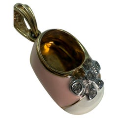 Its a girl pendant in 14KT yellow gold with enamel and diamonds baby shooe