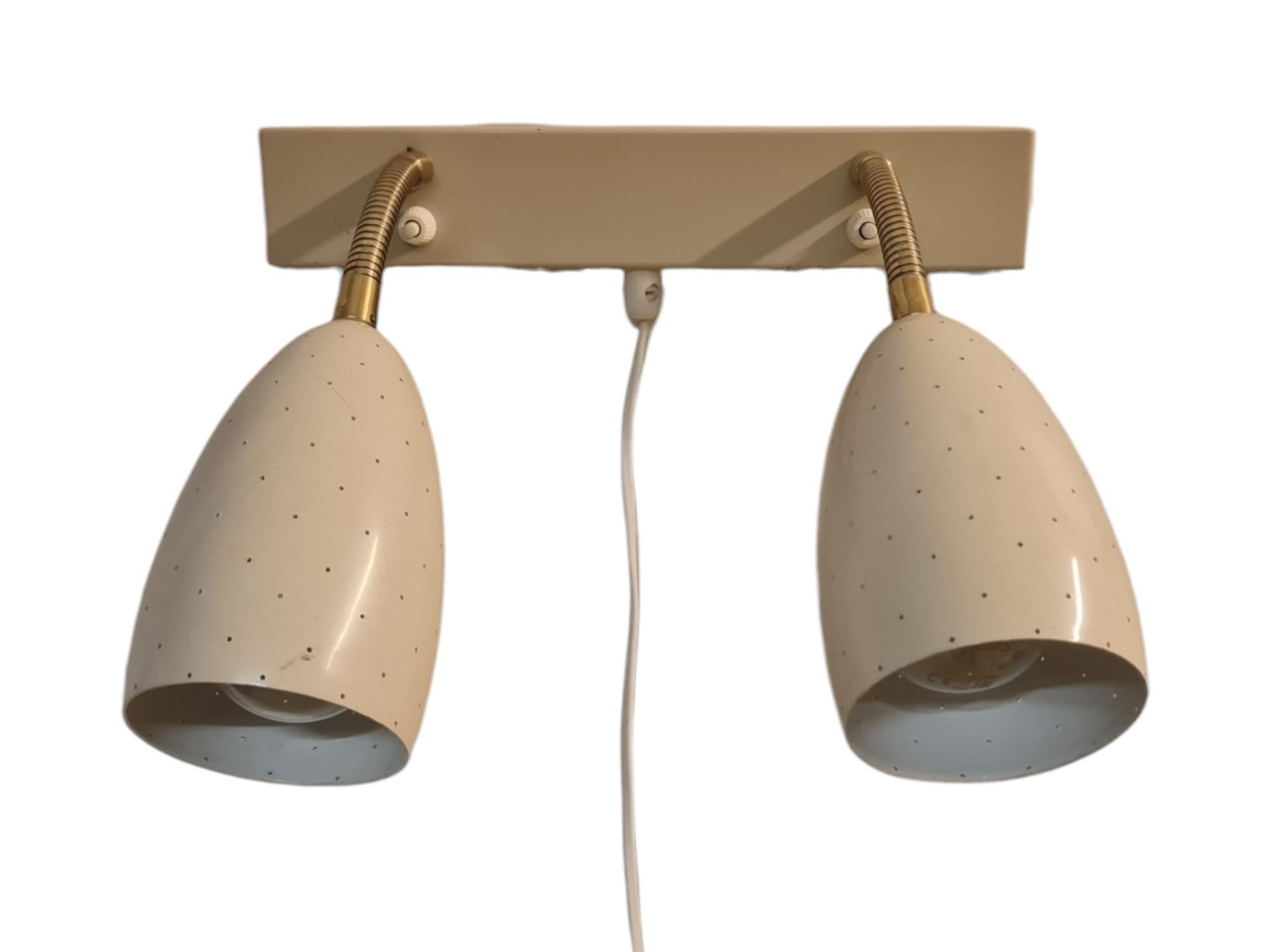 A rare adjustable mid-century modern wall lamp model EY 56, manufactured by Itsu in Finland in the 1950s. The lamp is meant as a reading lamp above double beds with two adjustable light spots that can be turned in different directions by a goose