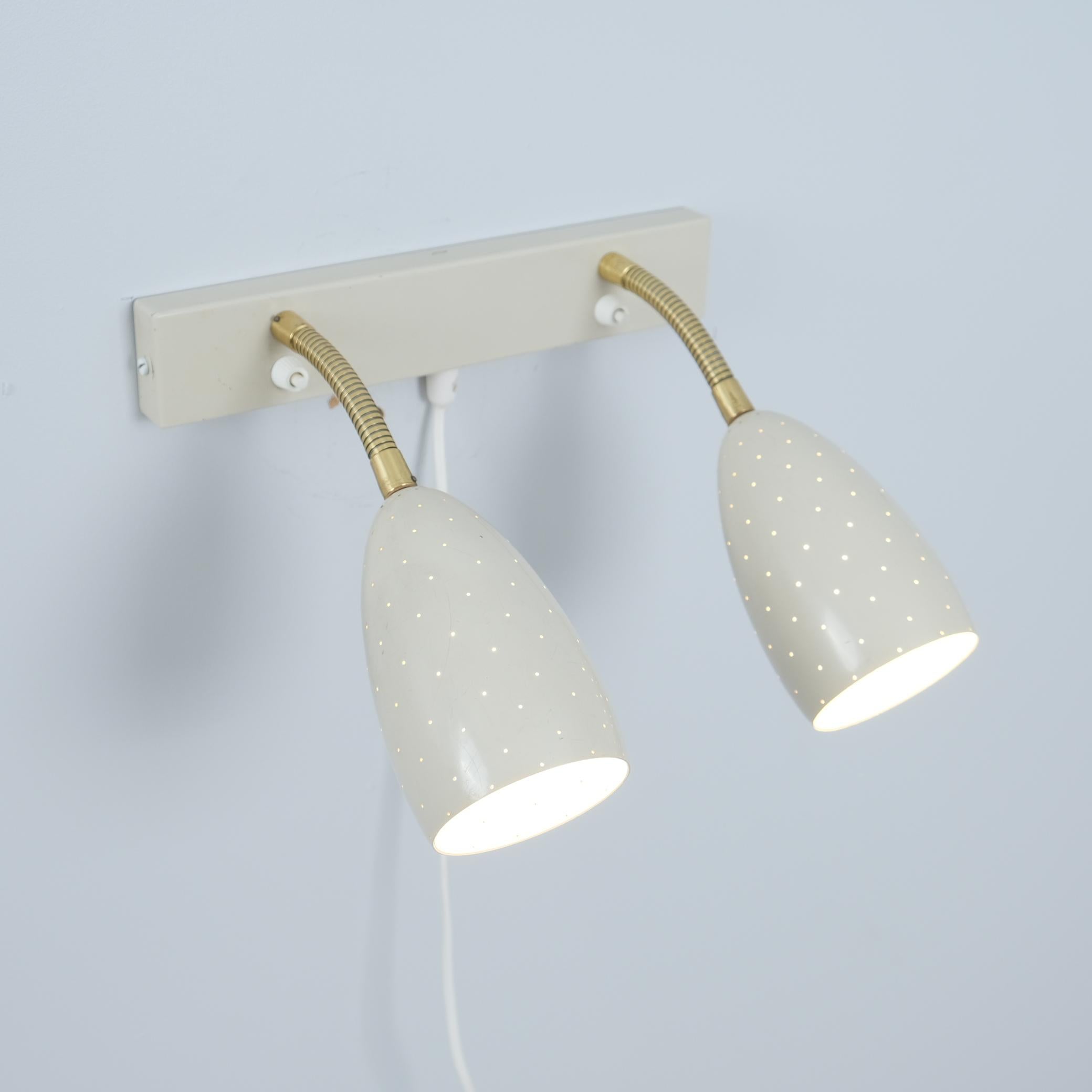 Una rara lámpara de pared regulable de estilo moderno de mediados de siglo, modelo EY 56, fabricada por Itsu en Finlandia en la década de 1950. La lámpara está pensada como lámpara de lectura sobre camas de matrimonio, con dos puntos de luz