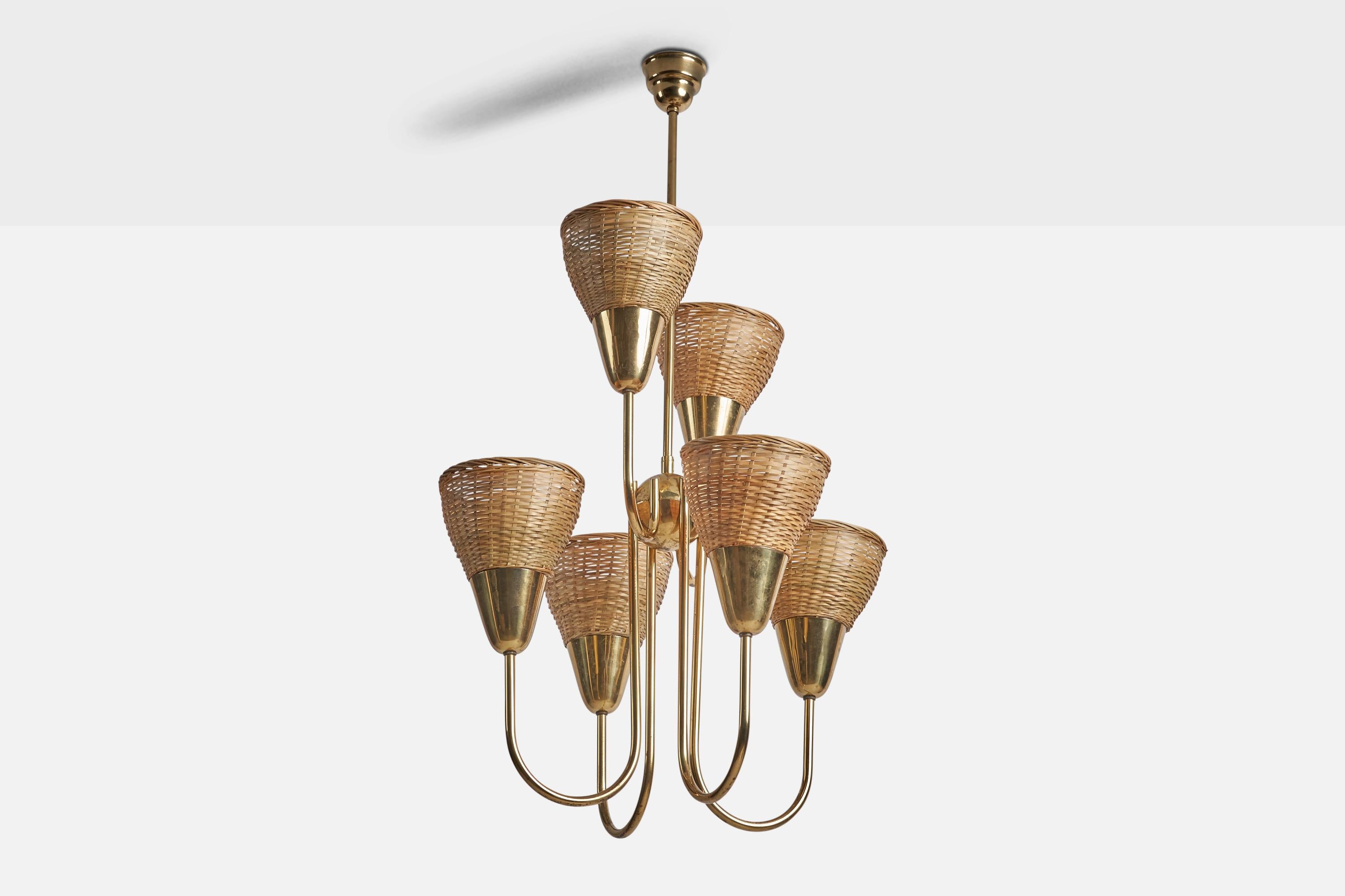 A sizeable brass and rattan chandelier designed and produced by Itsu, Finland, 1950s.

Overall Dimensions (inches): 41.75” H x 24.5” Diameter
Back Plate Dimensions (inches): 3.5” Diameter
Bulb Specifications: E-26 Bulb
Number of Sockets: 6
All