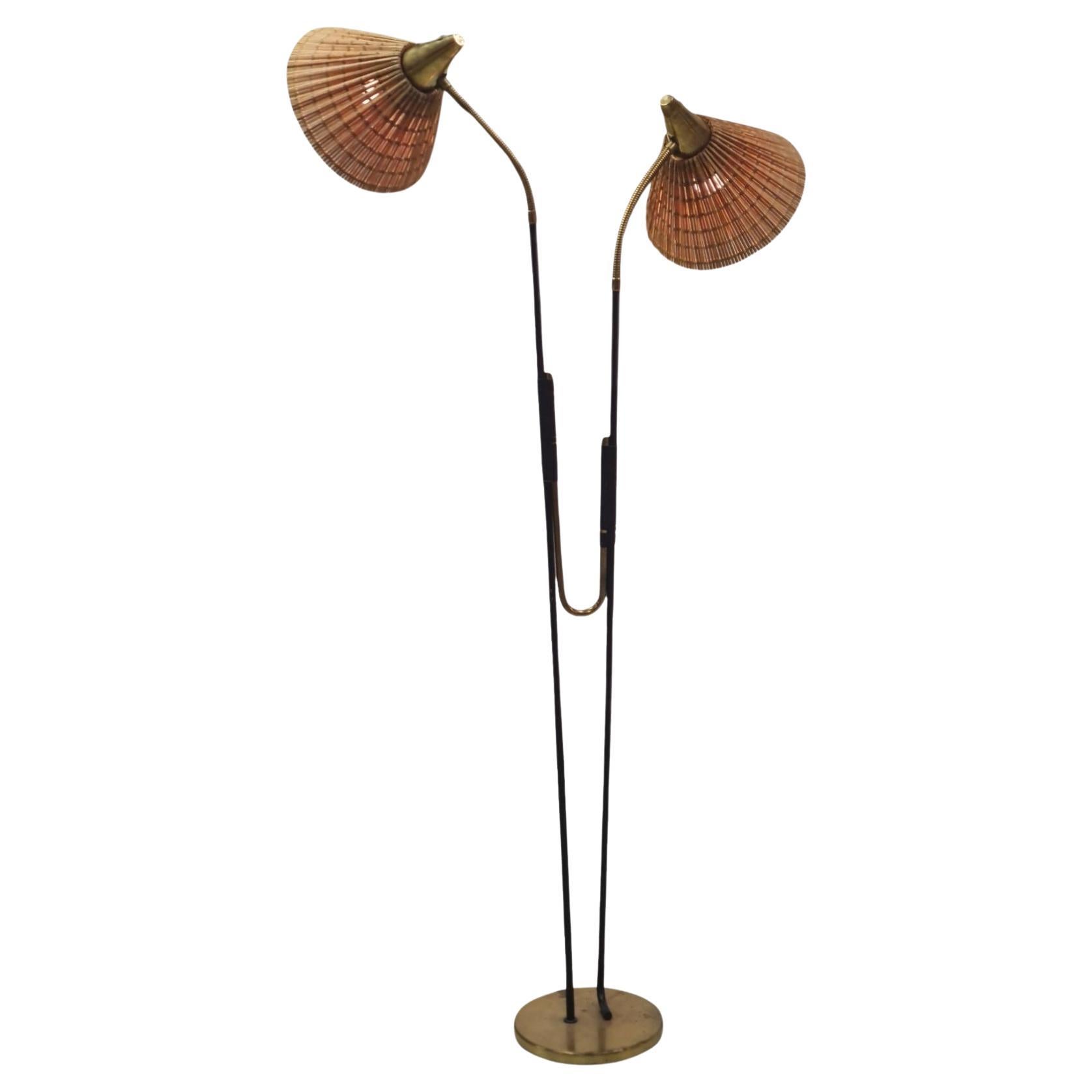 A somewhat rare Itsu floor lamp with a beautiful design displaying two distinct light heads, that can be adjusted to almost any direction desired. The black painted metal, and the brass parts suit each other perfectly in this elegant and quite