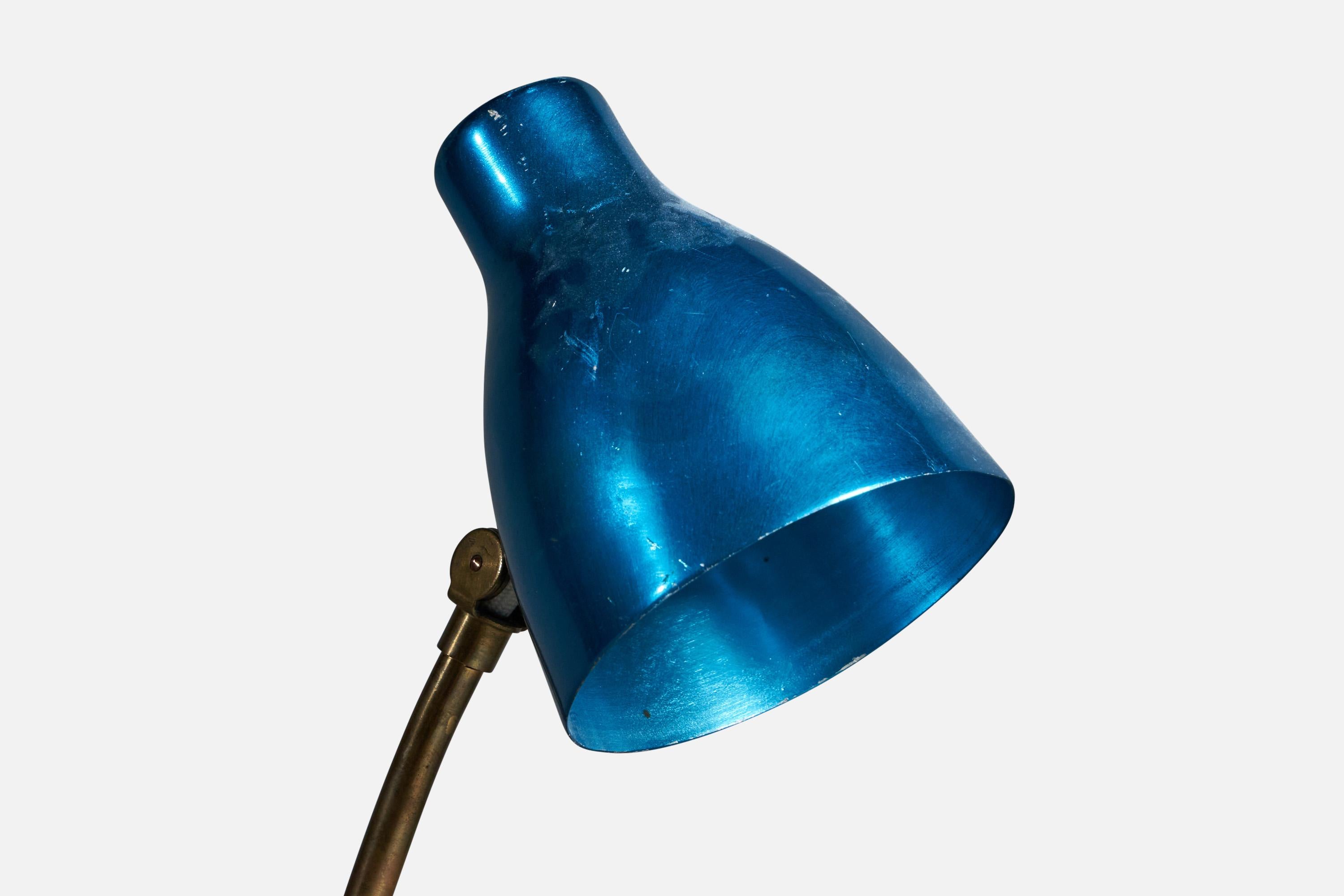 A rare modernist table lamp by Finnish producer, Itsu. The base features molded and bent brass wrapped in natural leather. The adjustable screen in anodized aluminum.

Very similar model illustrated in the manufacturer's catalog. The blue galvanized