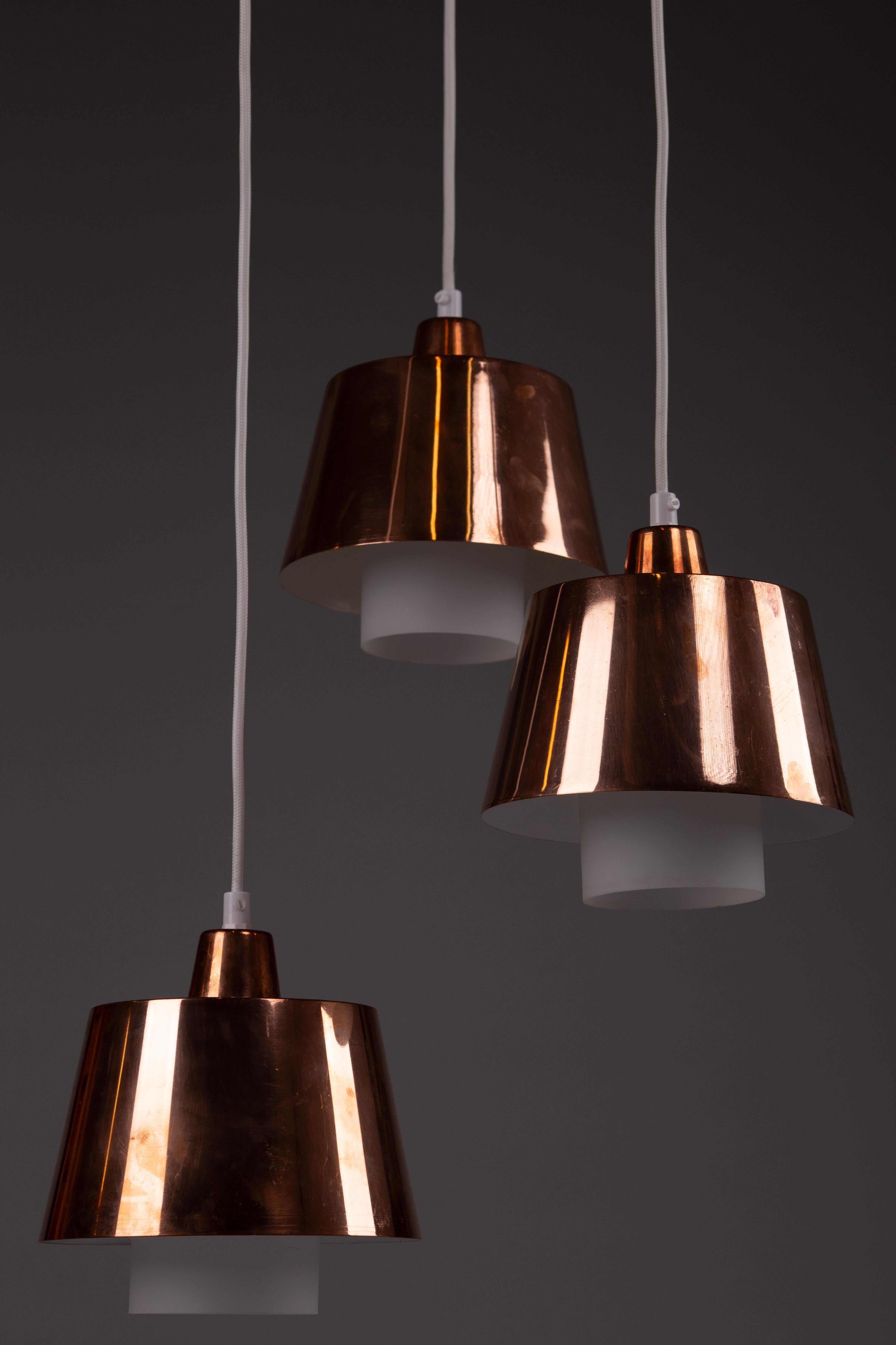 Illumina il tuo spazio con il set di 3 lampade a sospensione in rame finlandesi degli anni '50 Itsu, ognuna delle quali incarna l'eleganza senza tempo del design vintage scandinavo. Unificata in un unico apparecchio di pregio, questa lampada è