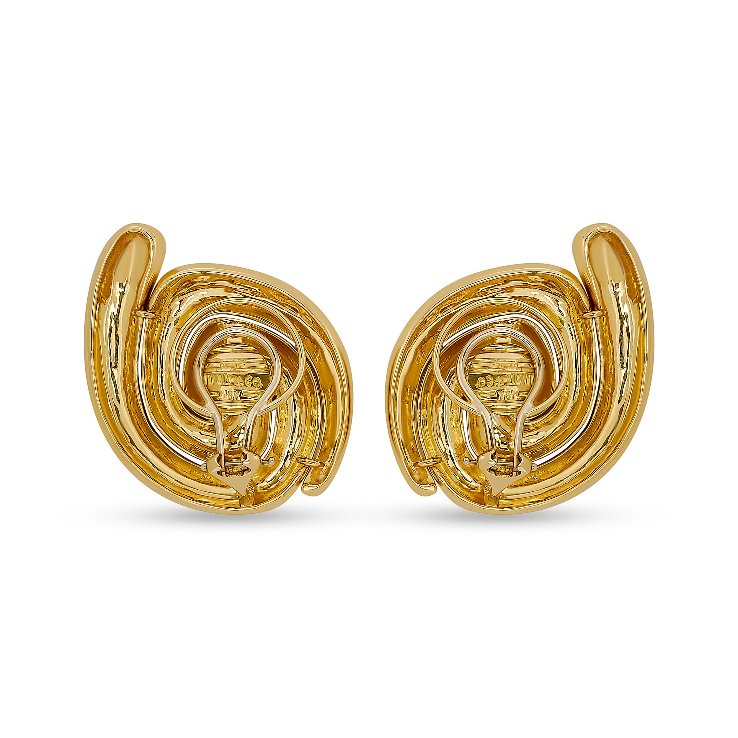 These Ivan & Co. clip-on earrings feature a bold, sculptural design in polished 18 karat yellow gold, showcasing a dynamic swirl motif that adds a touch of modern elegance to any look.

Stamped: 
