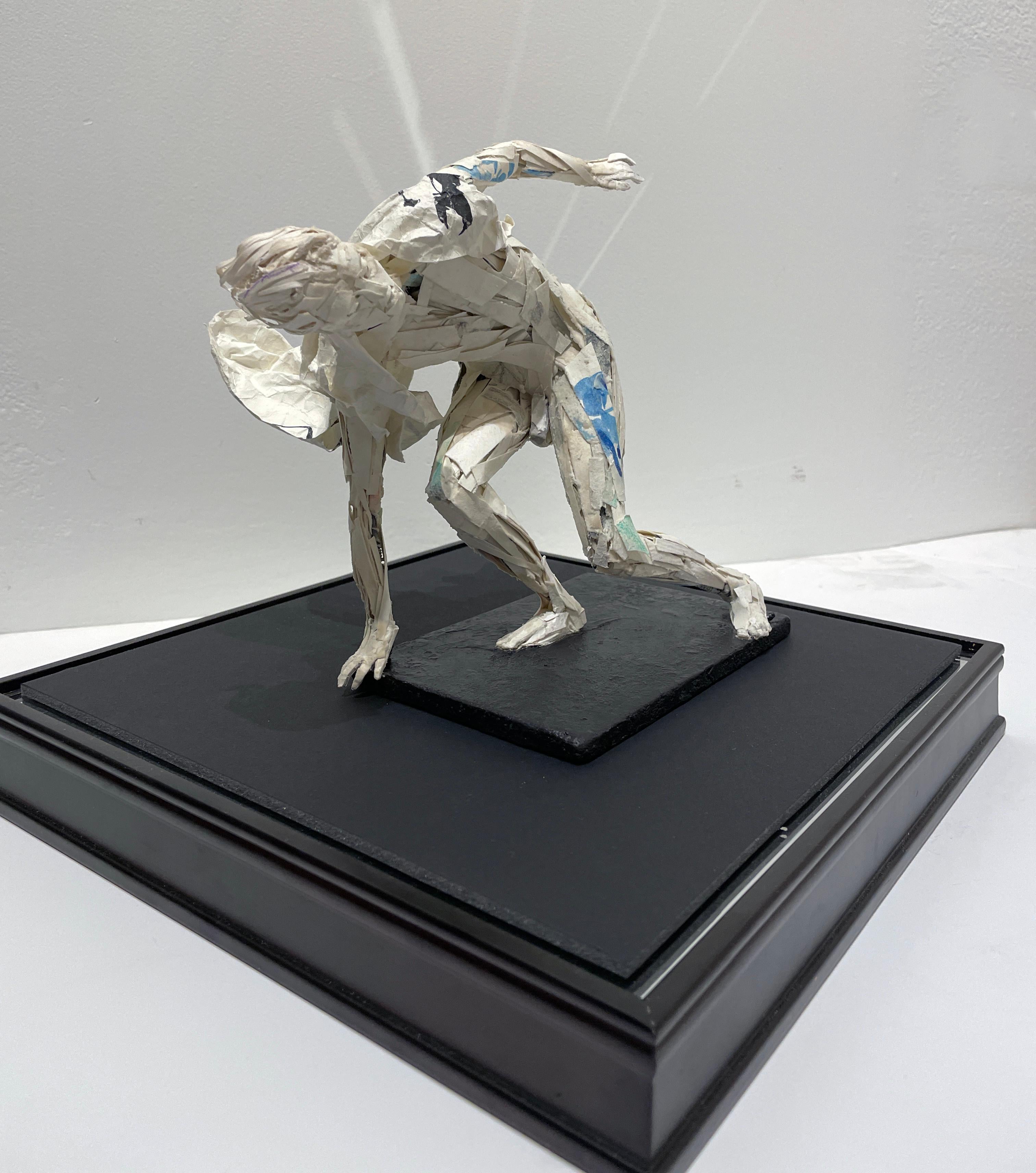 La figure masculine qui se rattrape avant de tomber au sol dans la sculpture en papier d'Ivan Markovic, 