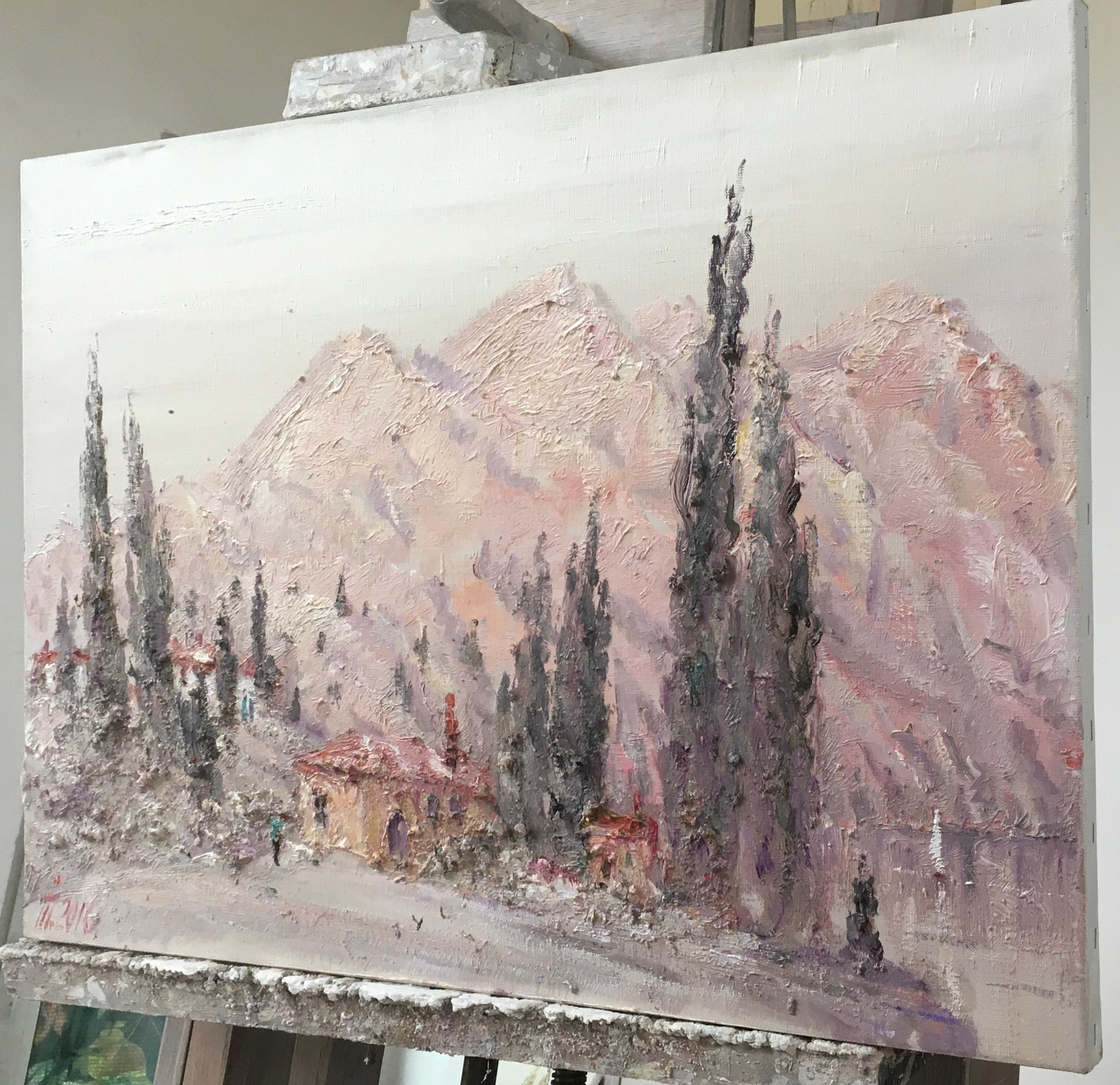 This painting depicts a peaceful, gentle landscape of a mountain village. In the foreground is a small house with a reddish-brown roof and light, almost sandy walls. Nearby grow tall, dark cypress trees, whose vertical silhouettes contrast with the