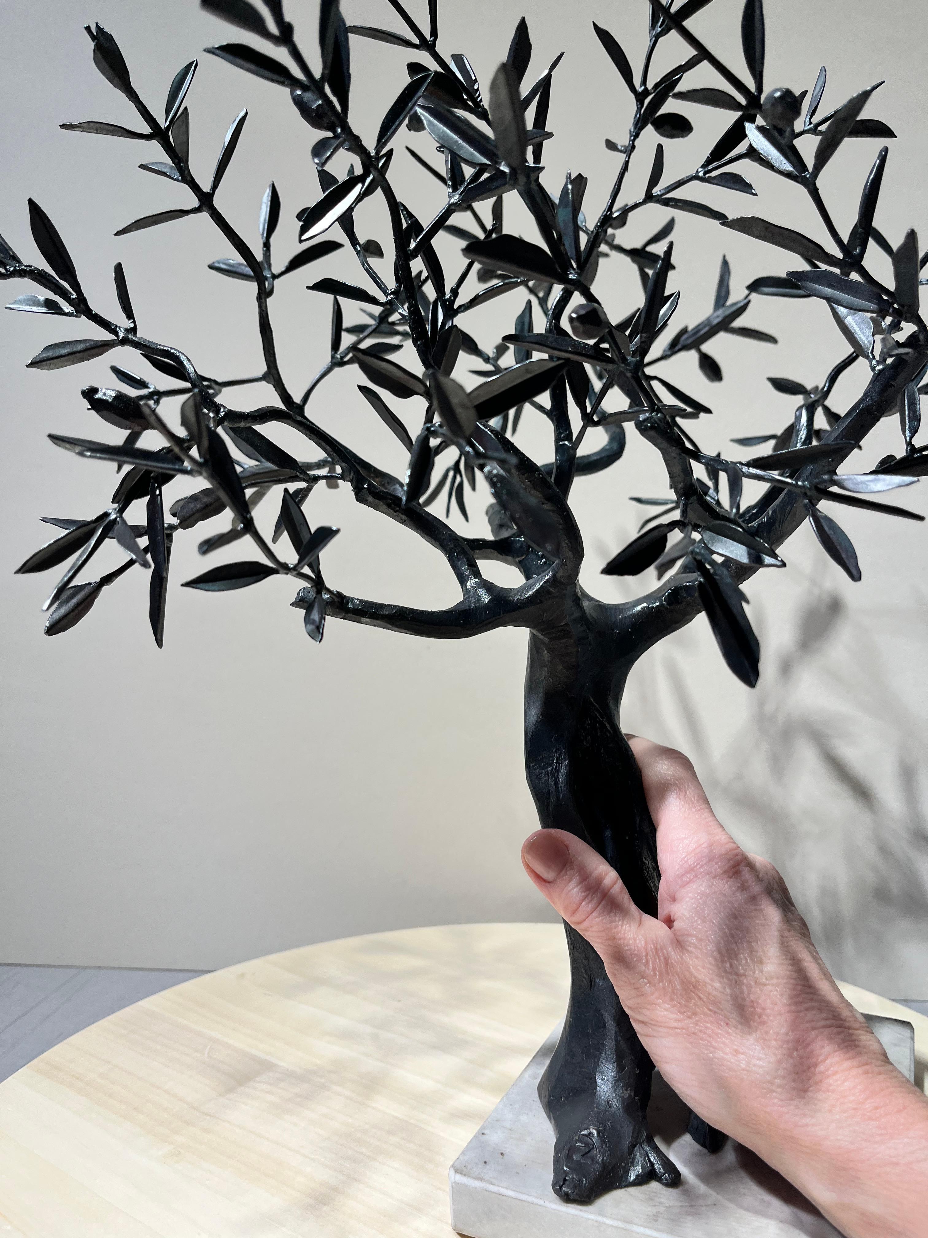 The Olive tree's unique piece forged in wrought iron is not replicable. It was created by one of the most significant contemporary worldwide artist-blacksmith. He is Italian. 

Fixed on a small white marble base, the sculpture, although small in