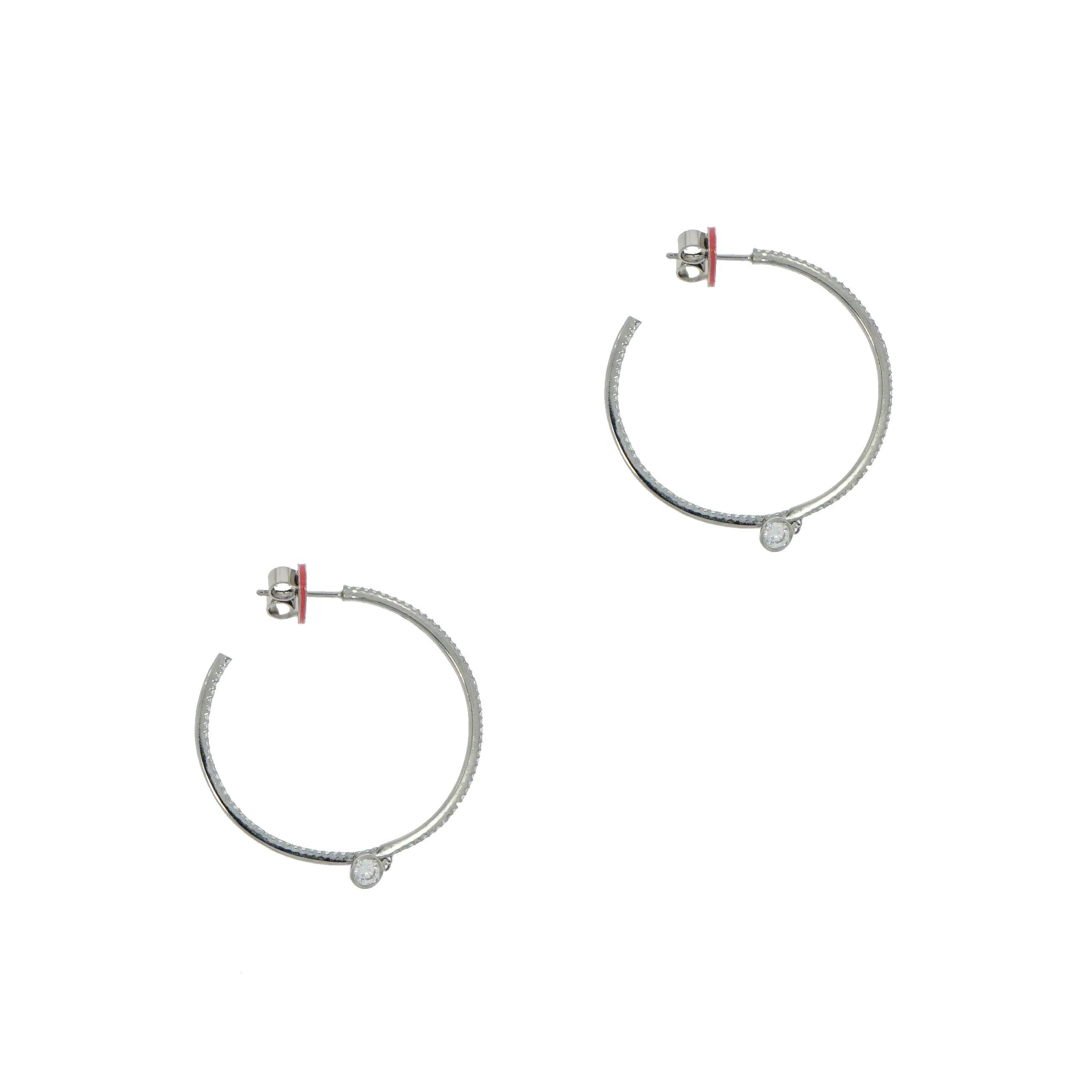 Designed by Ivanka Trump, these thin diamond hoop earrings are crafted in 18k white gold with round brilliant cut, bezel-set diamond charm. Containing 182 round brilliant cut diamonds and weighing 1.16 total carats (G-H color/SI1 clarity).  
A must