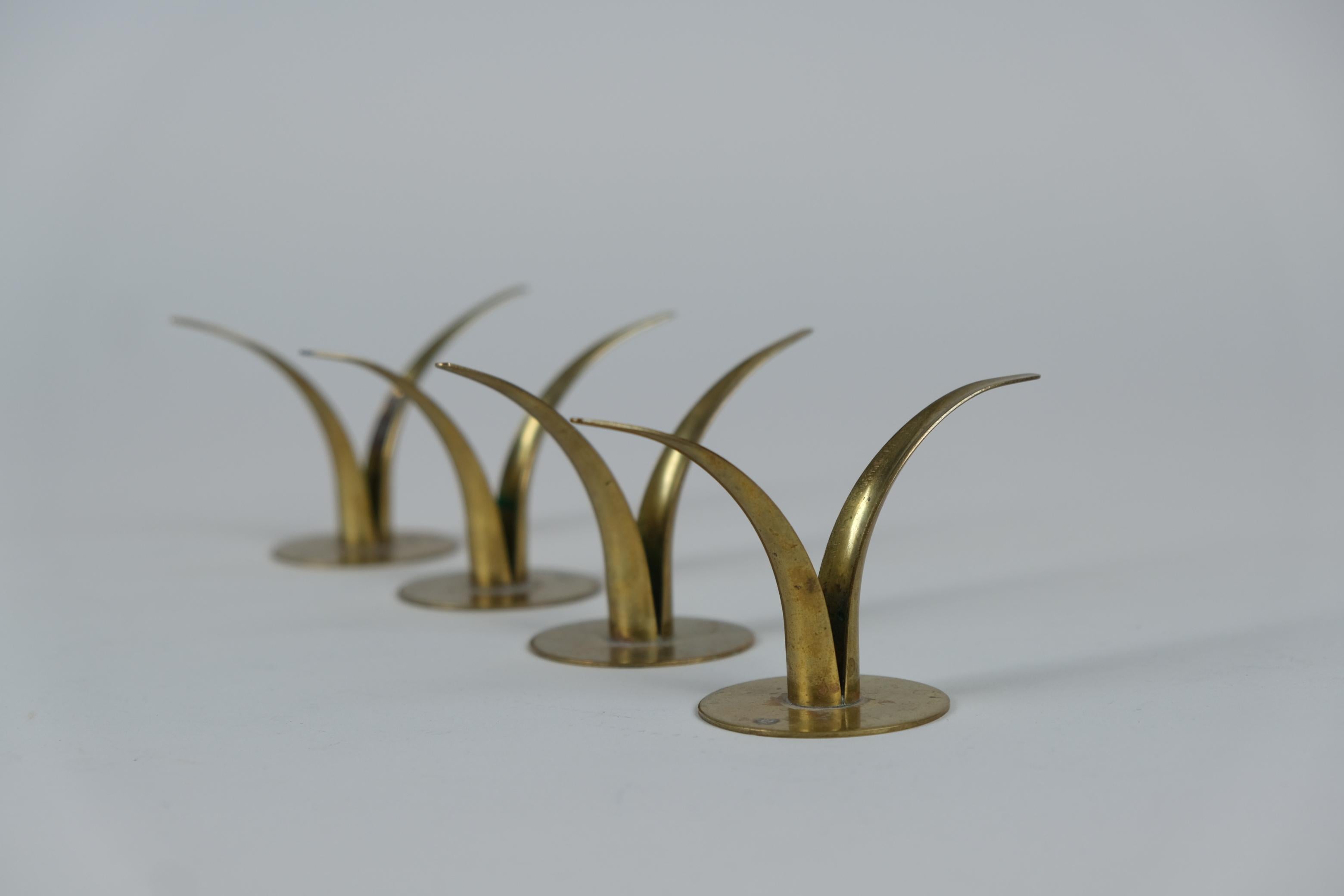 A set of 4 very beautiful and delicate candleholders designed by Ivar Ålenius Björk in 1939 and manufactured by Ystad Metall in Sweden. These pieces are a part of a series of candle holders in different sizes and shapes but in this same distinctive