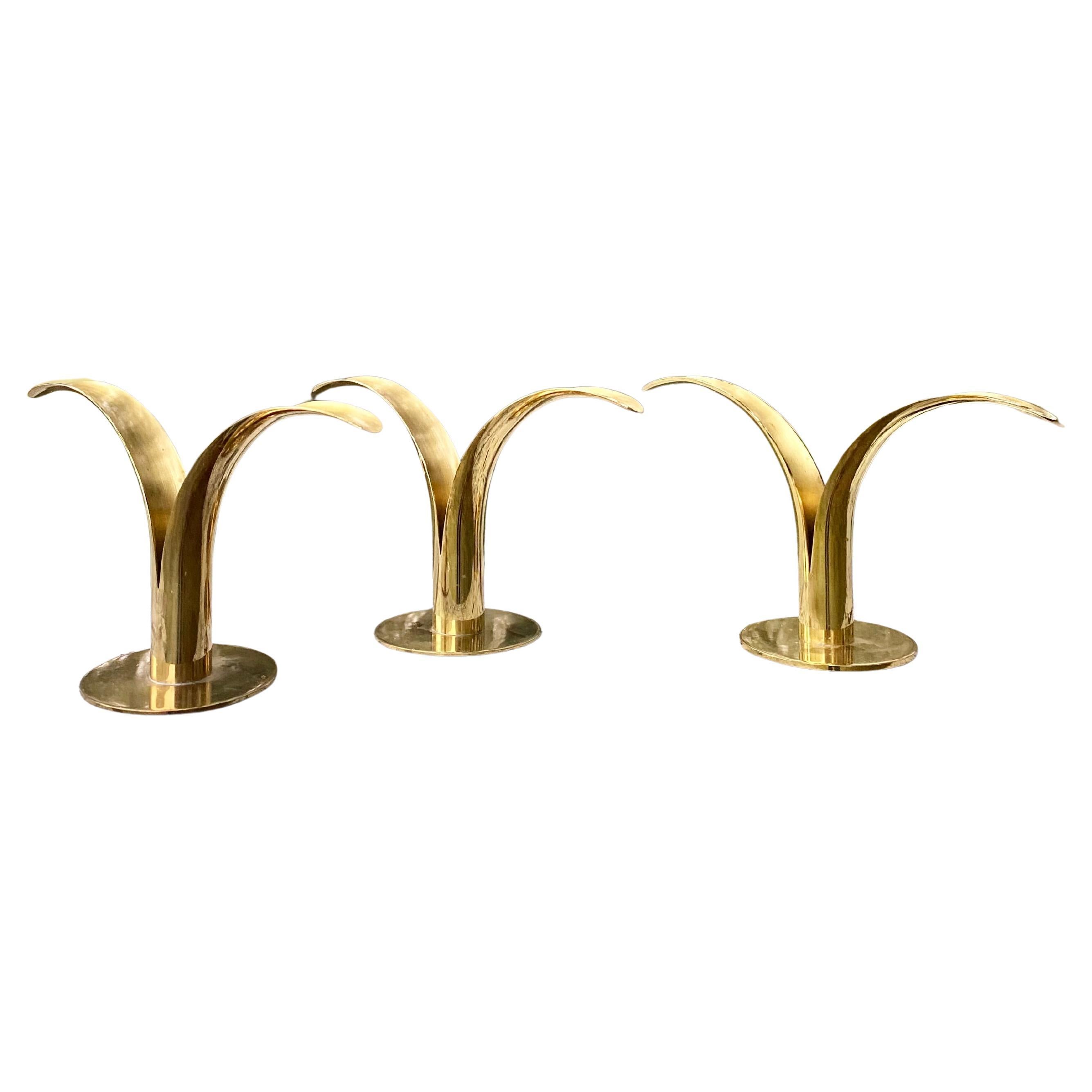 Elegante set di tre portacandele scultorei in ottone, prodotti in Svezia da Ystad-Metall, design di Ivar Ålenius Björk del 1939. Una coppia è abbinata in ottone spazzolato e contrassegnata da 