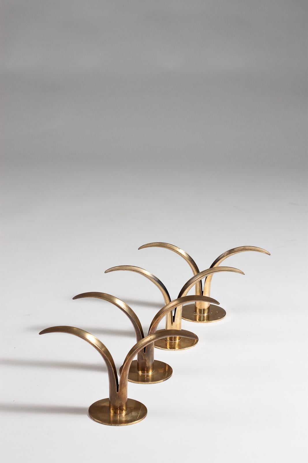 Add a touch of vintage elegance to your home with this set of 4 Liljan brass candlesticks from the 1940's. Designed by Ivar Ålenius Björk for Ystad Metall, these candlesticks are a true representation of Scandinavian interior design. The sleek and
